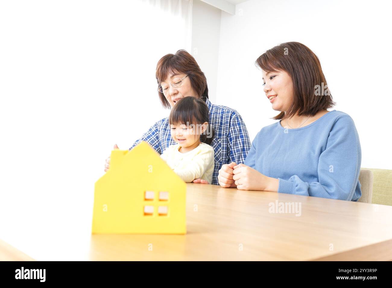 Trois générations trouvant une image de maison Banque D'Images