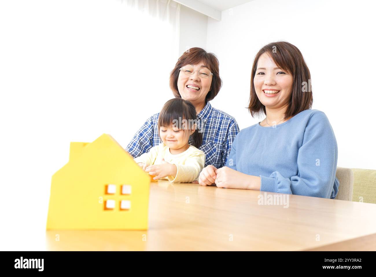 Trois générations trouvant une image de maison Banque D'Images