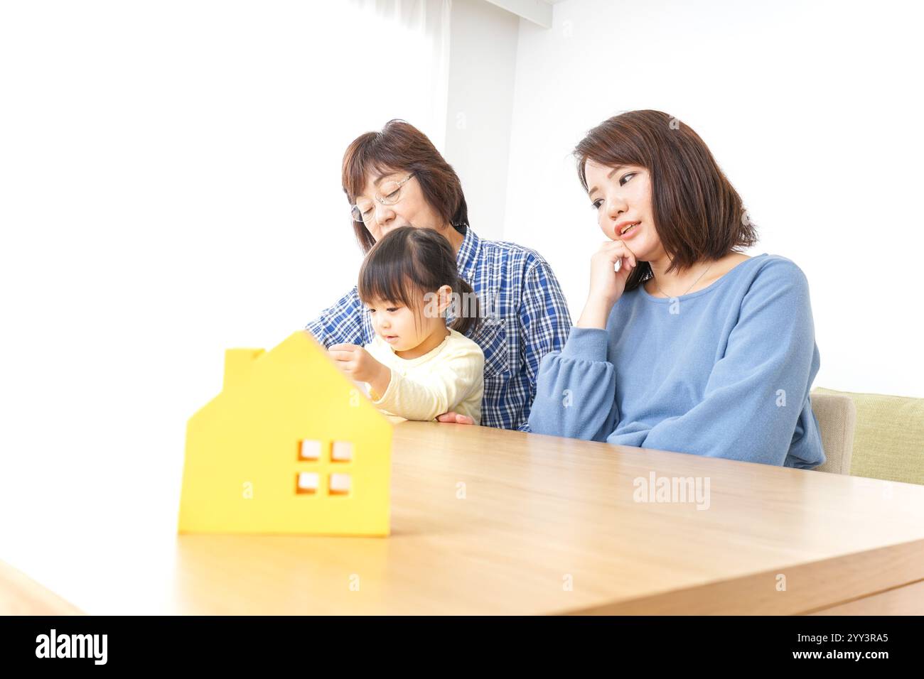 Trois générations trouvant une image de maison Banque D'Images