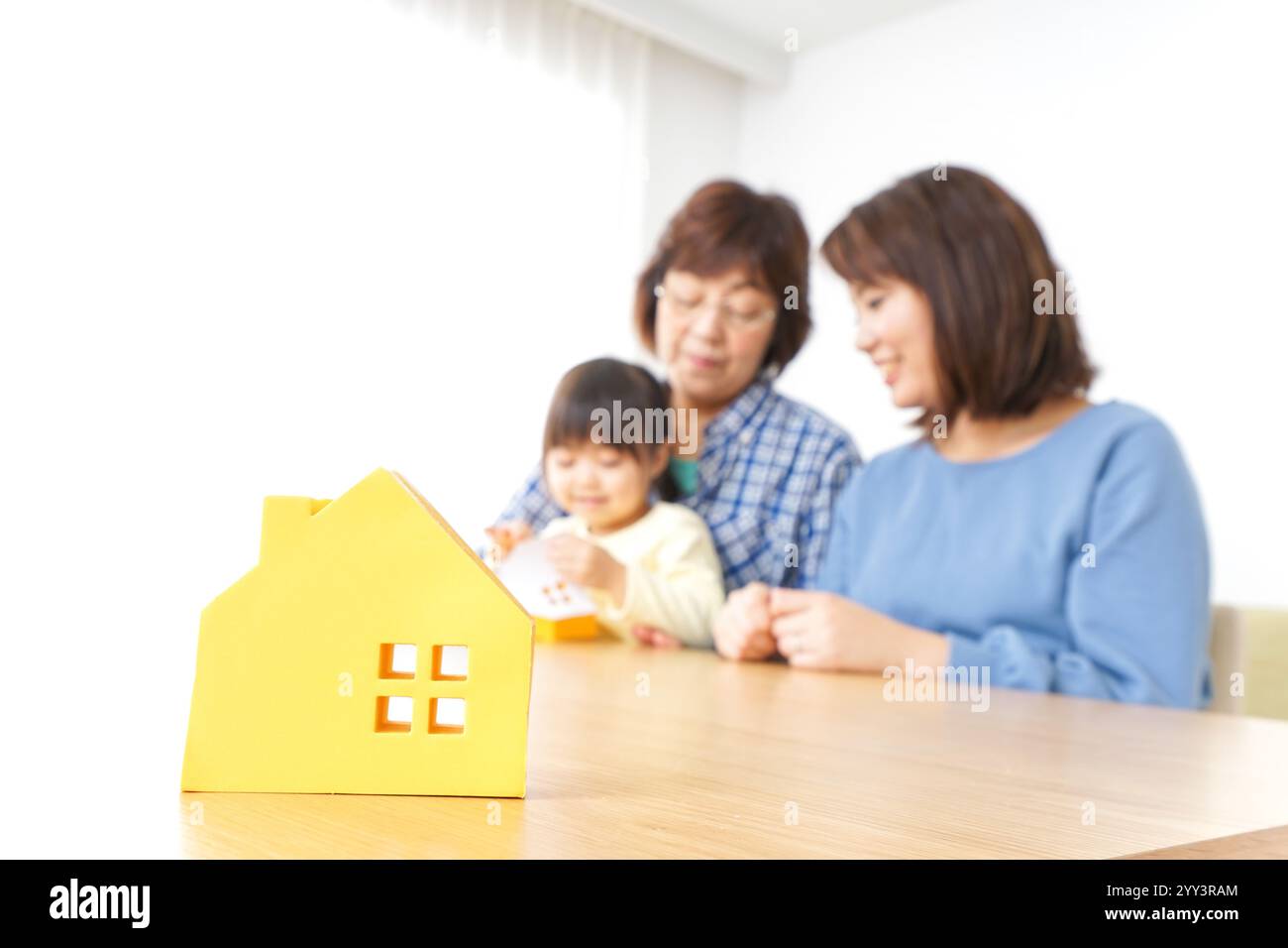 Trois générations trouvant une image de maison Banque D'Images