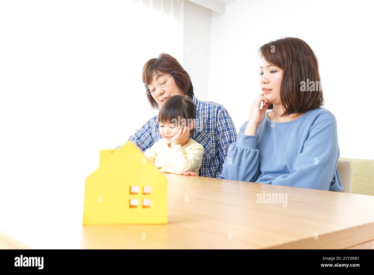 Trois générations trouvant une image de maison Banque D'Images