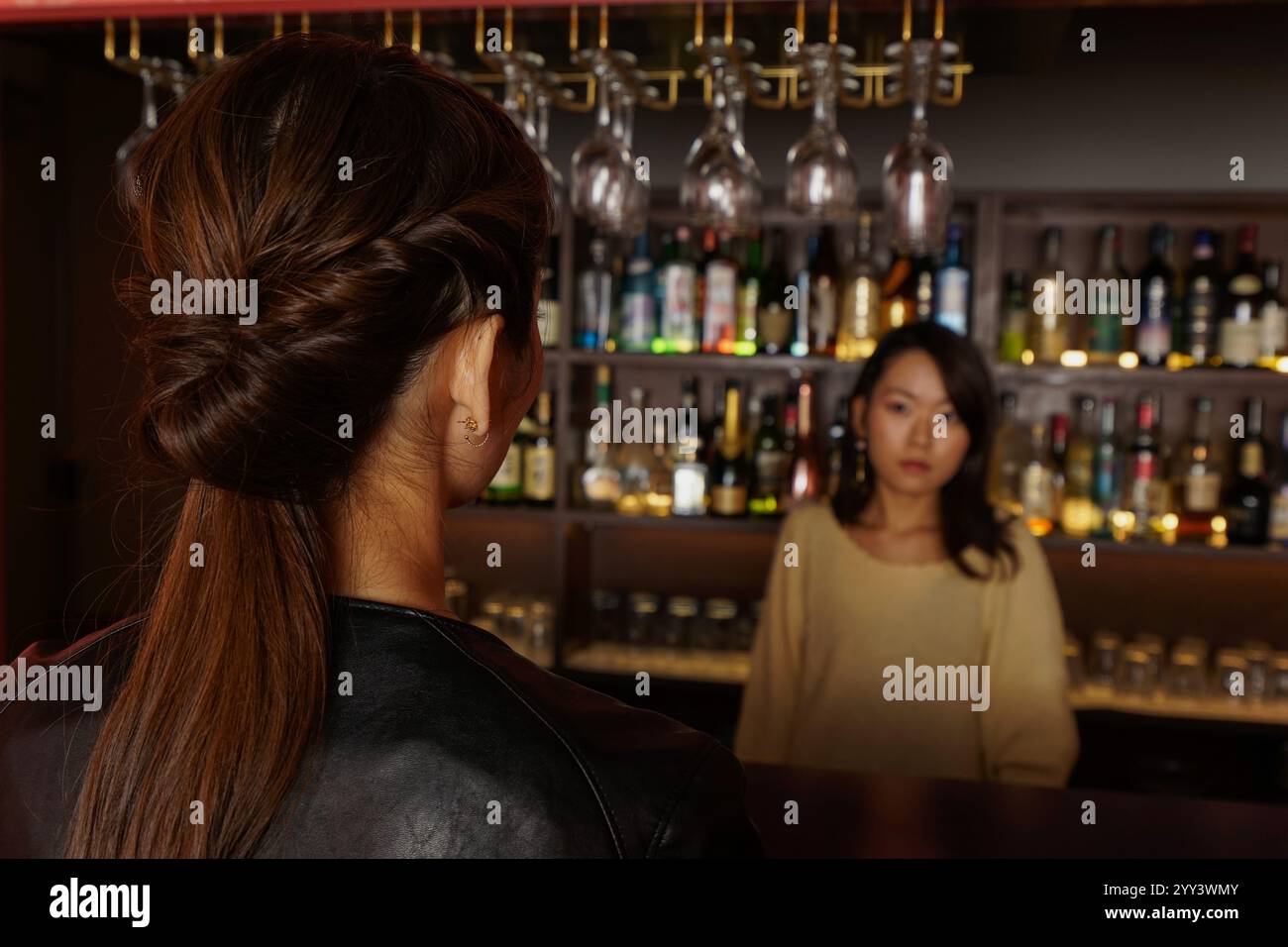 Femme assise au comptoir du bar Banque D'Images