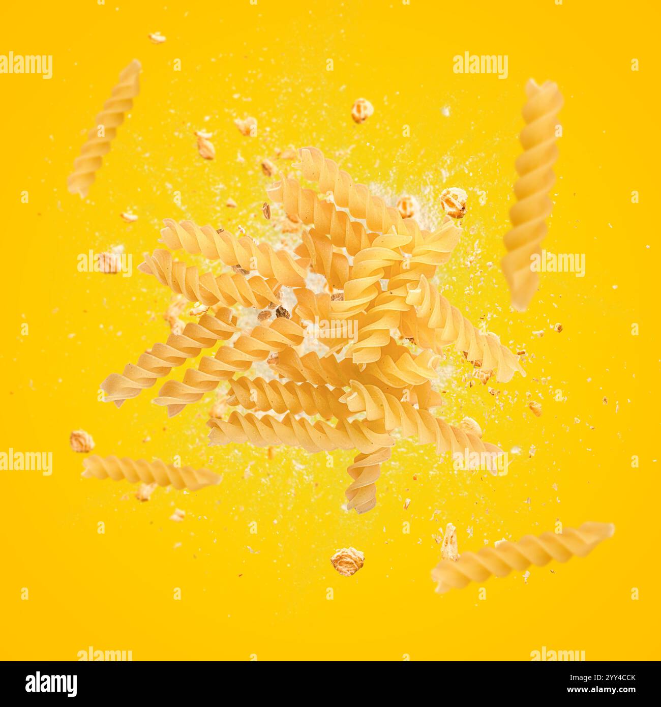 Pâtes fusilli volant sur fond jaune avec de la farine et de l'avoine Banque D'Images