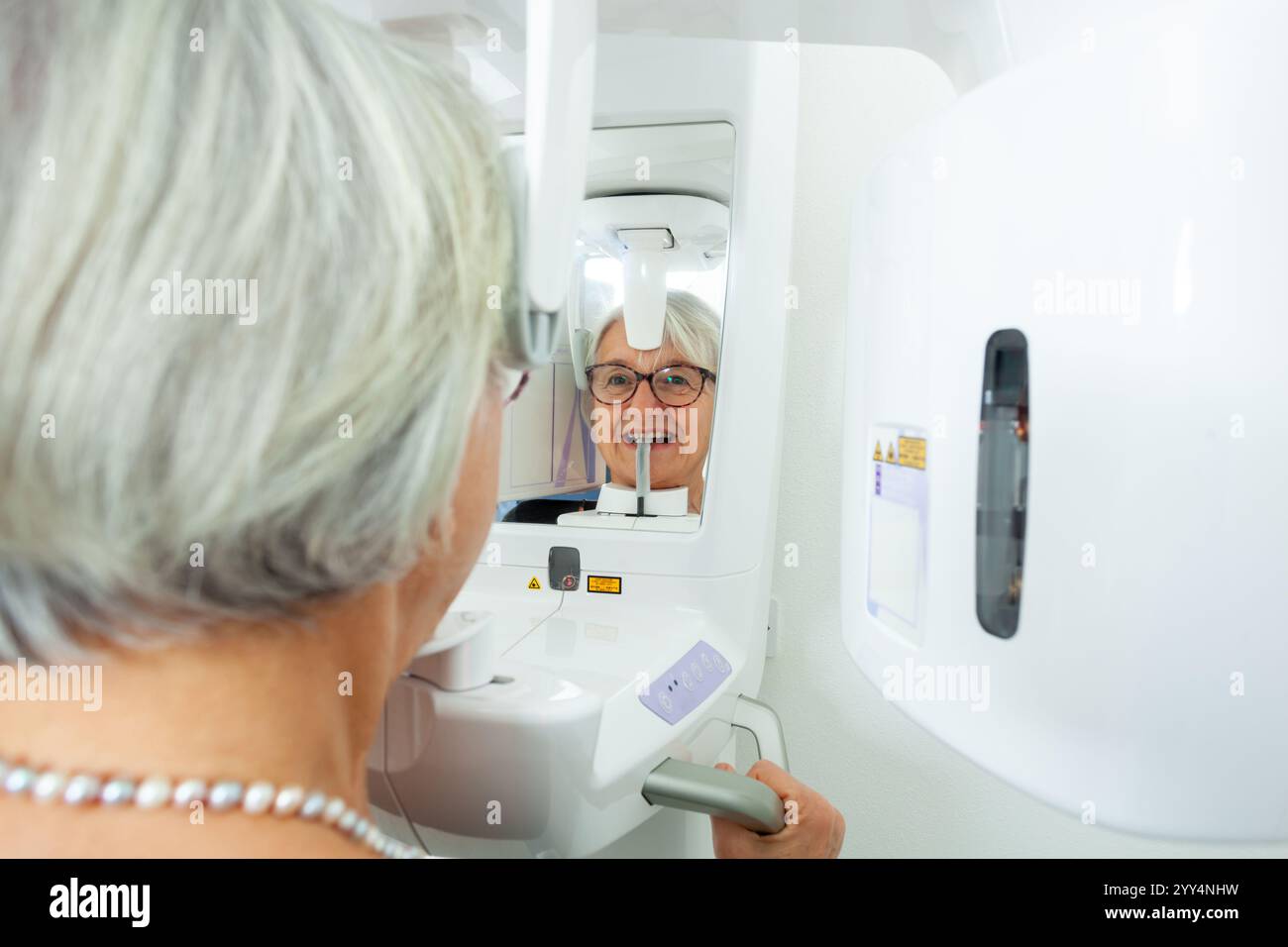 Femme âgée recevant un examen de radiographie dentaire dans une clinique dentaire de pointe, mettant en évidence la technologie et les soins dentaires modernes Banque D'Images