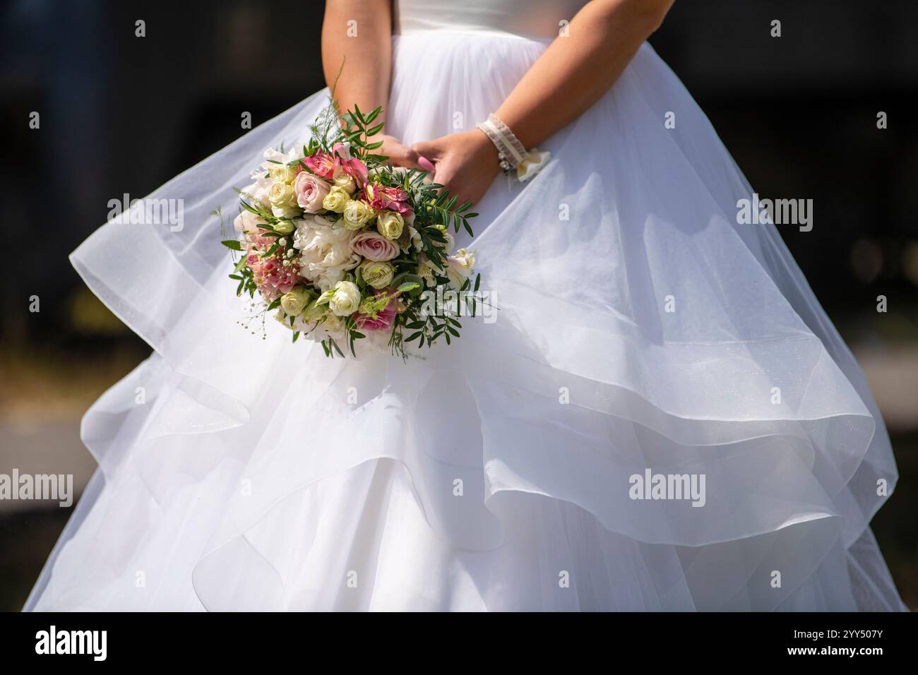 Belle mariée tient un bouquet de mariage dans les mains. Robe de mariée, détails de mariage. Banque D'Images