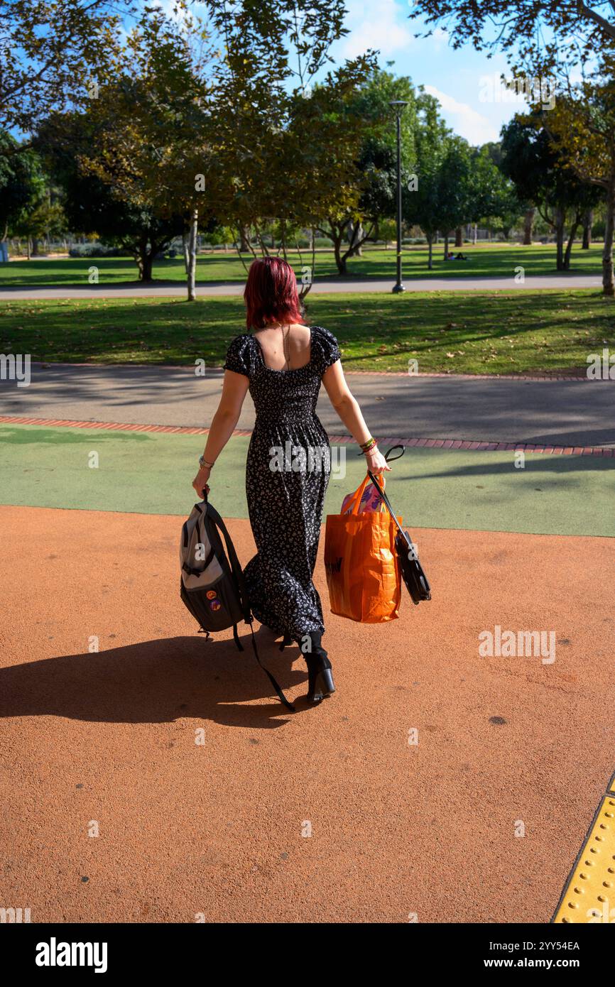 Je suis en route, je ne sais pas où je vais jeune, belle femme dans la vingtaine avec dos à l'appareil photo transporte ses sacs loin de l'autorisation du modèle du spectateur Banque D'Images