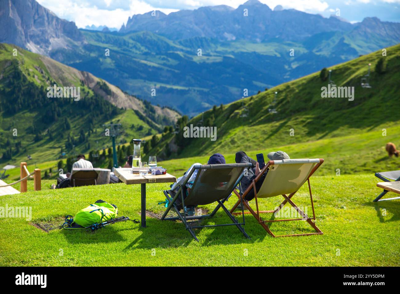 Les touristes assis dans des chaises longues sur un café-terrasse verdoyant apprécient la vue spectaculaire de Seceda, Dolomites, Italie Banque D'Images