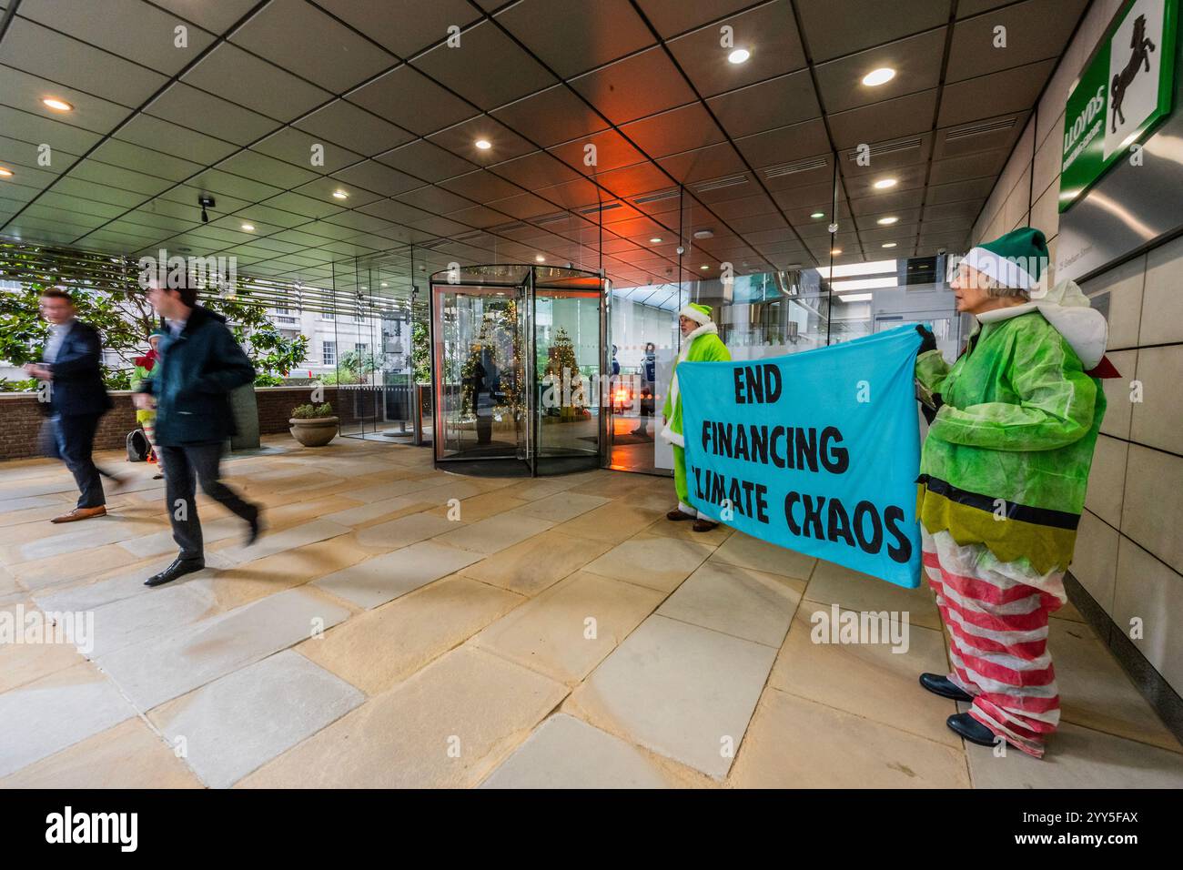 Londres, Royaume-Uni. 19 décembre 2024. Une rébellion d'extinction Green Santa et ses elfes piquèrent l'entrée principale et distribuèrent des tracts pour demander à Lloyds Bank de «nettoyer leur acte!» et pour mettre fin au financement du chaos climatique. Les manifestants pensent que Lloyds pourrait être un leader sur le climat, mais « ne prennent pas les mesures nécessaires ». La manifestation a eu lieu devant le siège de la Banque à Gresham Street, dans la ville de Londres. Crédit : Guy Bell/Alamy Live News Banque D'Images