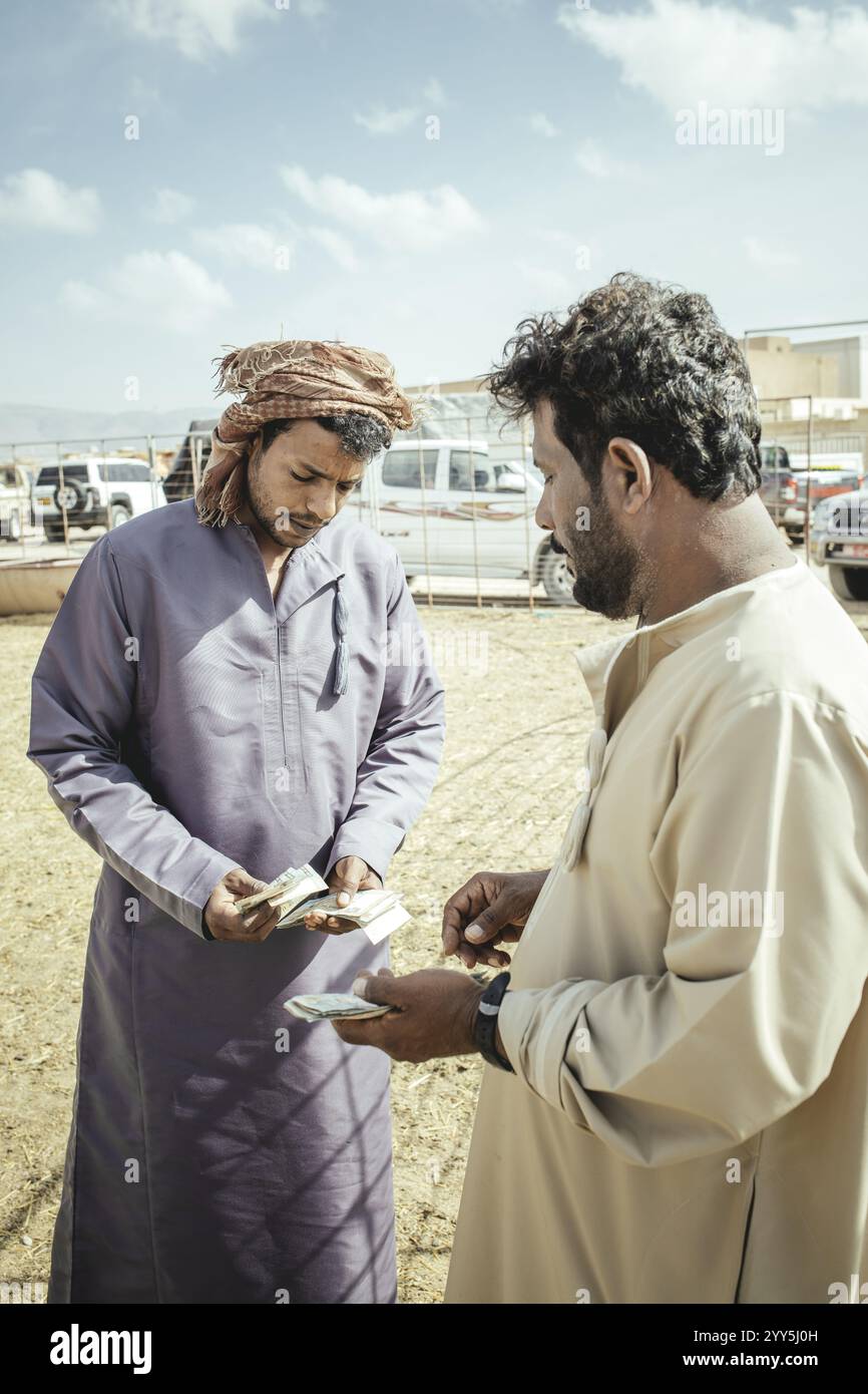 Revendeur de chameaux avec client, souk de chameaux Salalah, Dhofar, Oman, Asie Banque D'Images