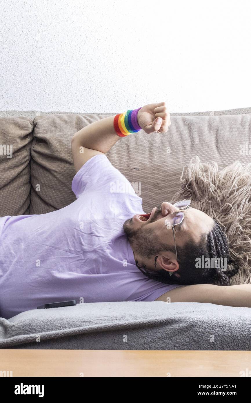 Jeune homme paresseux couché sur un canapé endormi. Homme détendu allongé sur le canapé dans l'appartement. Homme paresseux allongé sur un canapé Banque D'Images