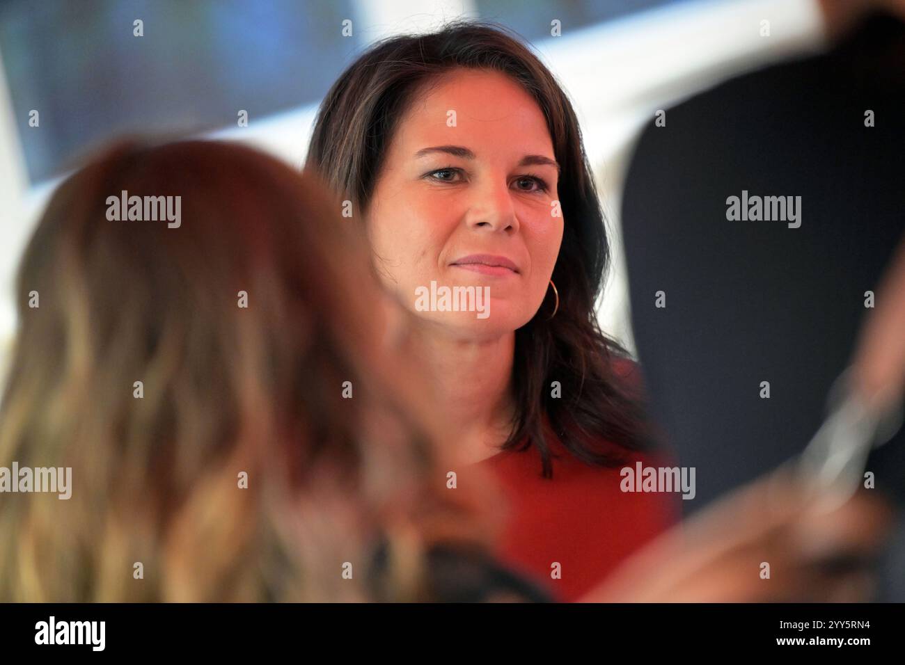 Potsdam, Allemagne. 19 décembre 2024. Annalena Baerbock (Alliance 90/les Verts, R), ministre fédérale des Affaires étrangères, s’entretient avec des invités sur un stand AWO au centre communautaire de Schlaatz. Baerbock a visité la campagne 'From the Heart' organisée par l'association de district AWO à Potsdam. Crédit : Michael Bahlo/dpa/Alamy Live News Banque D'Images