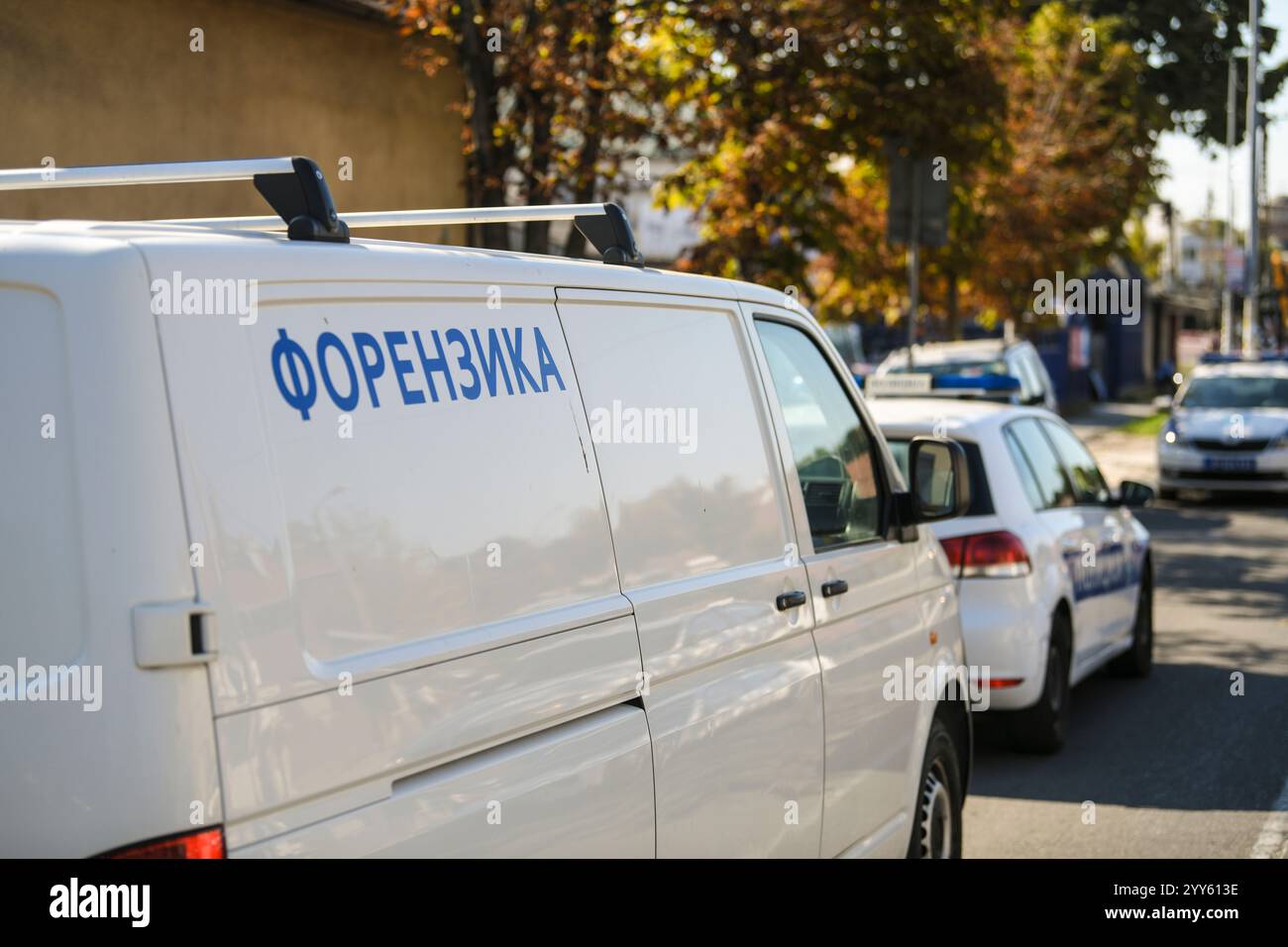 Voiture de service d'enquête médico-légale sur la scène du crime. Gros plan avec la voiture de police en arrière-plan. Traduction de Forenzika : '' Forensics'' Banque D'Images