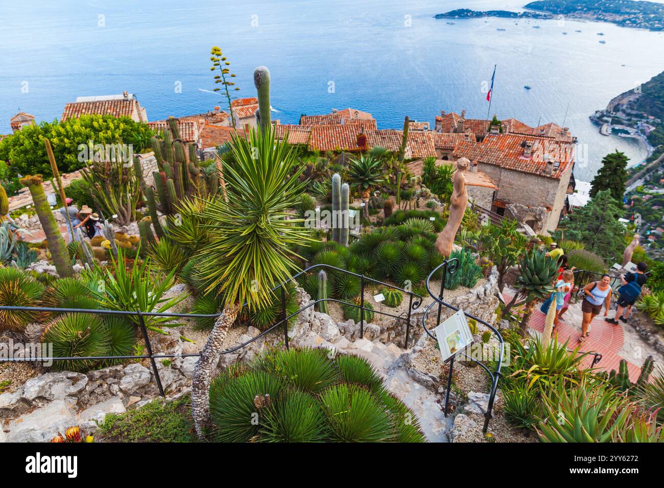 Èze, France - 15 août 2018 : paysage côtier, les gens marchent dans le parc public près de vieilles maisons avec des toits de tuiles rouges. Alpes-Maritimes Banque D'Images