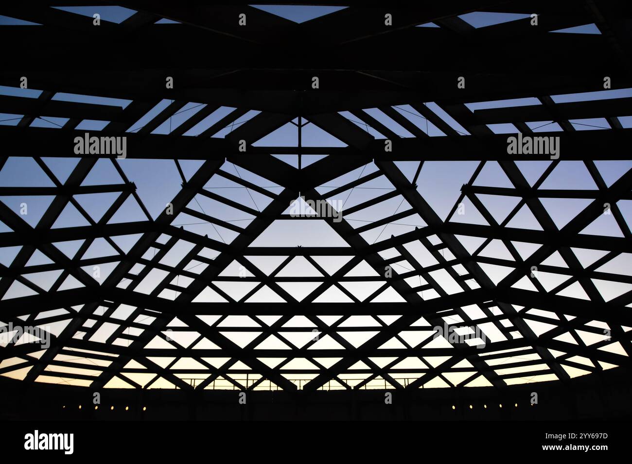 Silhouette de construction de toiture. Cadre de toit en bois avec lattes et chevrons de gouttière brillants du soleil, contre le ciel bleu. Bâtiment en cours de développement. Banque D'Images