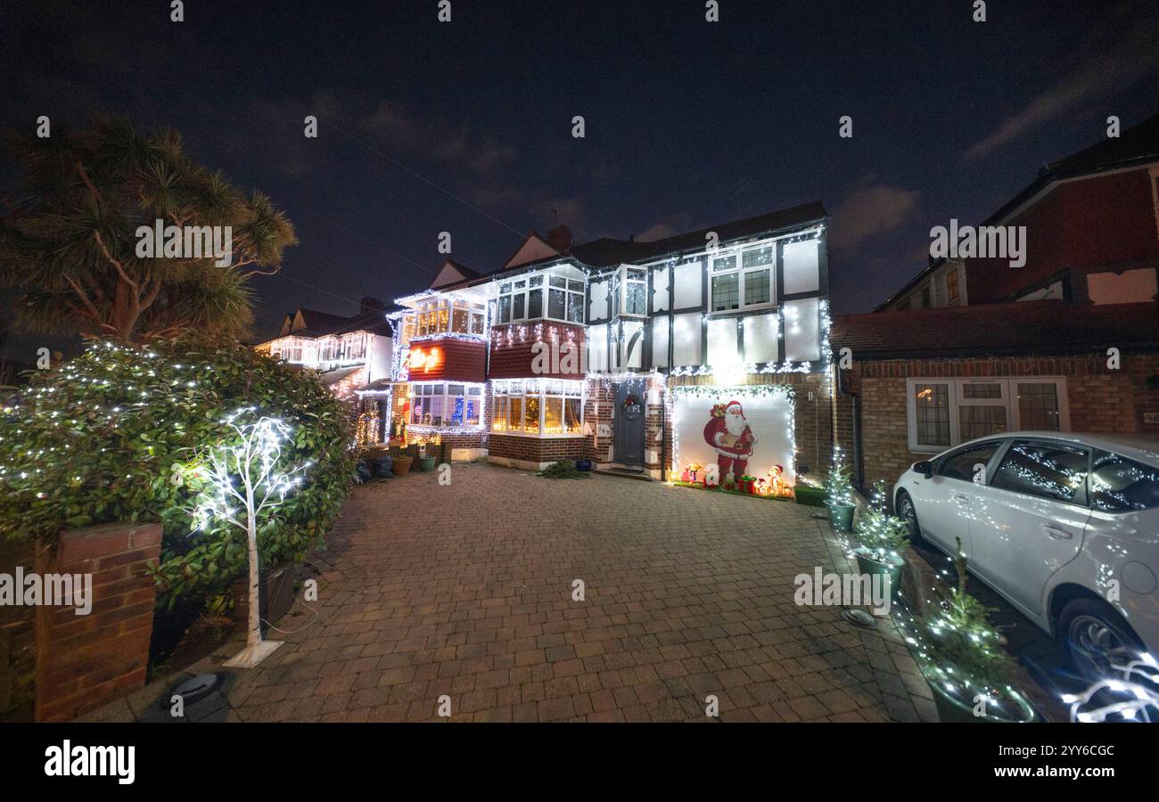 Lower Morden Lane, Surrey, Royaume-Uni. 19 décembre 2024. Les résidents de cette rue résidentielle du sud de Londres décorent l’extérieur de leur maison chaque année, amassant des fonds pour le St Raphael’s Hospice localement qui offre des soins palliatifs et de fin de vie aux habitants de Merton et Sutton. Cette année, ils ont créé une extravagance d'un quart de mile de long de lumières dans les jardins de devant, visités chaque soir par les familles qui apprécient le spectacle. Crédit : Malcolm Park/Alamy Live News Banque D'Images
