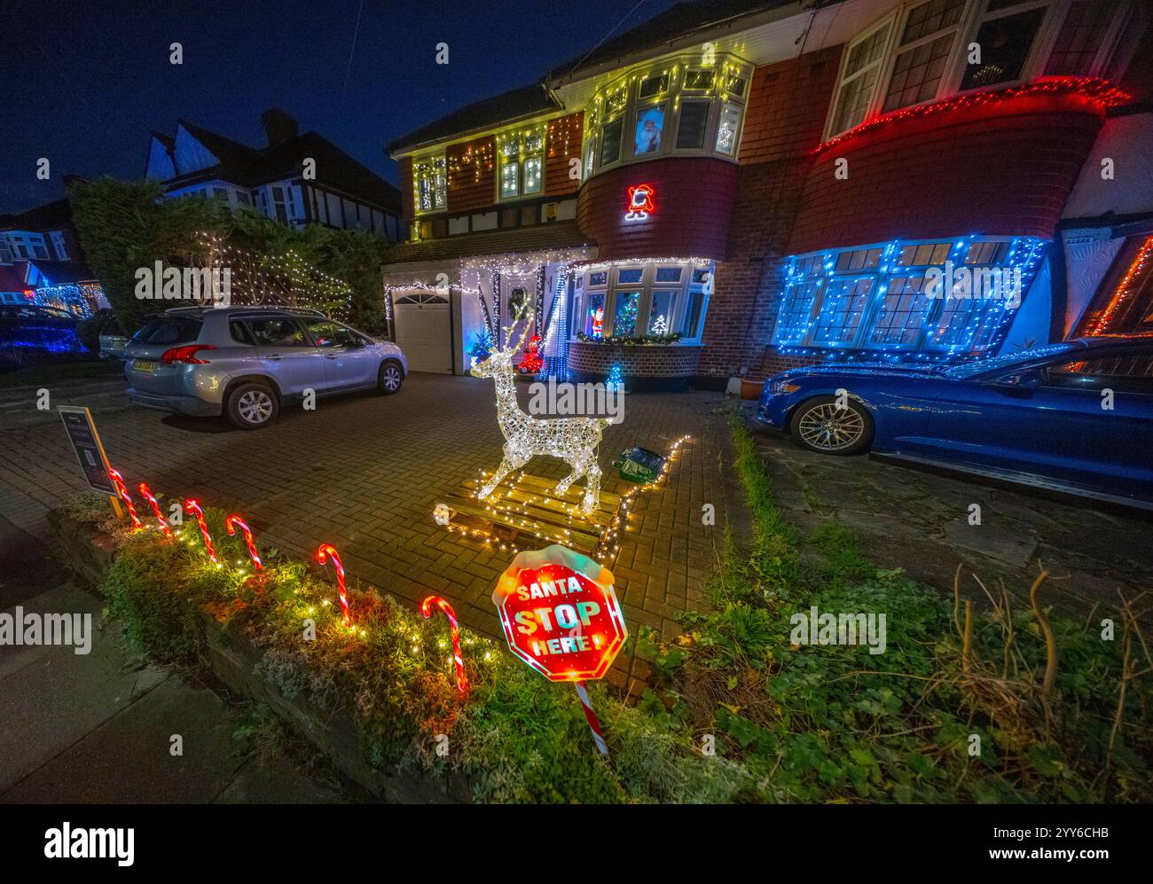 Lower Morden Lane, Surrey, Royaume-Uni. 19 décembre 2024. Les résidents de cette rue résidentielle du sud de Londres décorent l’extérieur de leur maison chaque année, amassant des fonds pour le St Raphael’s Hospice localement qui offre des soins palliatifs et de fin de vie aux habitants de Merton et Sutton. Cette année, ils ont créé une extravagance d'un quart de mile de long de lumières dans les jardins de devant, visités chaque soir par les familles qui apprécient le spectacle. Crédit : Malcolm Park/Alamy Live News Banque D'Images