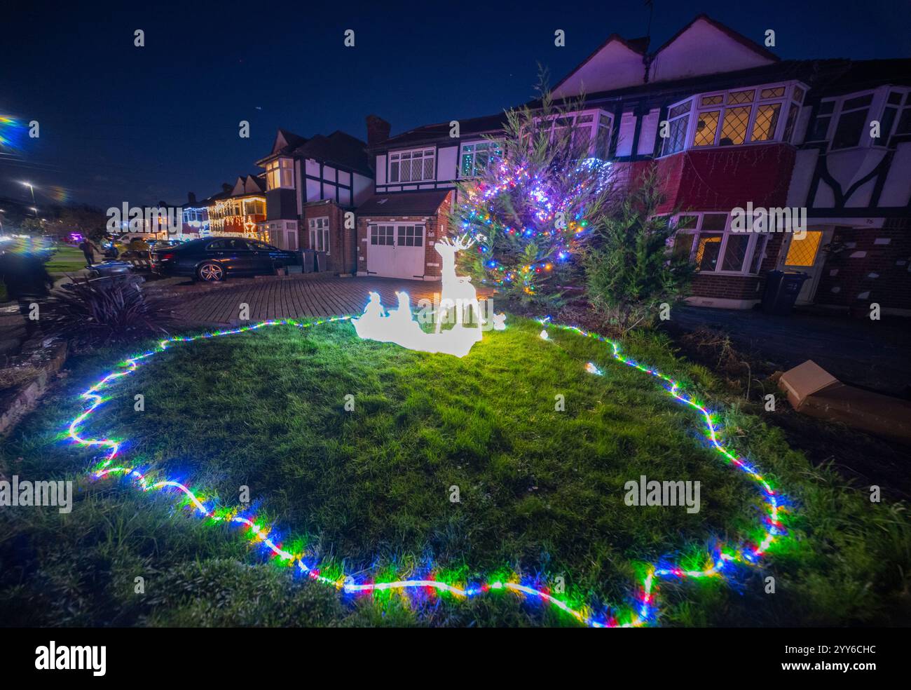 Lower Morden Lane, Surrey, Royaume-Uni. 19 décembre 2024. Les résidents de cette rue résidentielle du sud de Londres décorent l’extérieur de leur maison chaque année, amassant des fonds pour le St Raphael’s Hospice localement qui offre des soins palliatifs et de fin de vie aux habitants de Merton et Sutton. Cette année, ils ont créé une extravagance d'un quart de mile de long de lumières dans les jardins de devant, visités chaque soir par les familles qui apprécient le spectacle. Crédit : Malcolm Park/Alamy Live News Banque D'Images