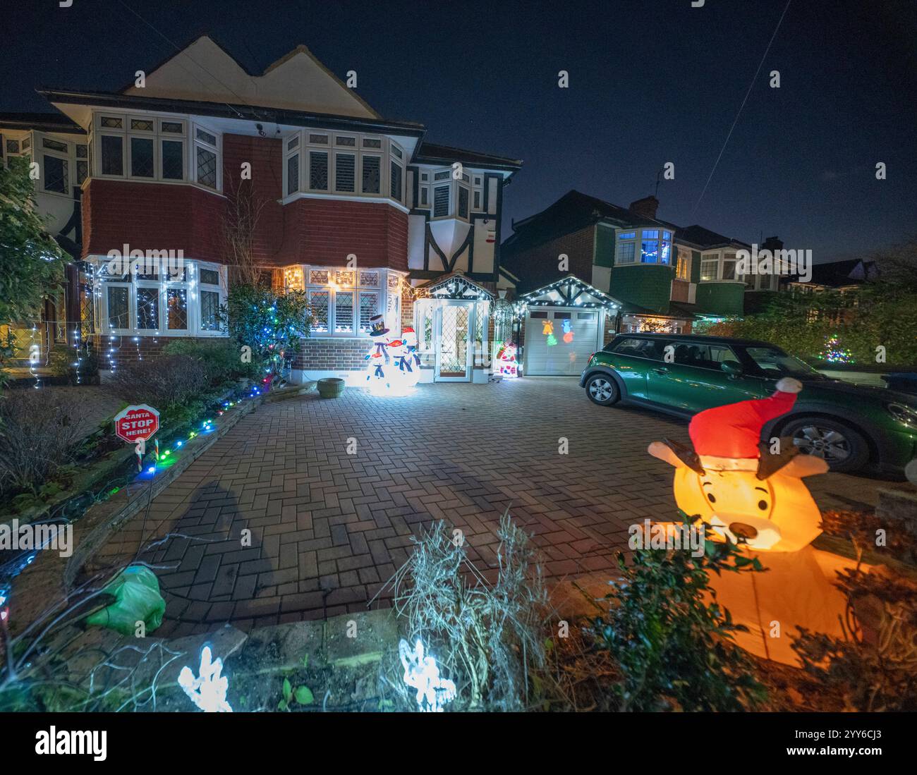 Lower Morden Lane, Surrey, Royaume-Uni. 19 décembre 2024. Les résidents de cette rue résidentielle du sud de Londres décorent l’extérieur de leur maison chaque année, amassant des fonds pour le St Raphael’s Hospice localement qui offre des soins palliatifs et de fin de vie aux habitants de Merton et Sutton. Cette année, ils ont créé une extravagance d'un quart de mile de long de lumières dans les jardins de devant, visités chaque soir par les familles qui apprécient le spectacle. Crédit : Malcolm Park/Alamy Live News Banque D'Images