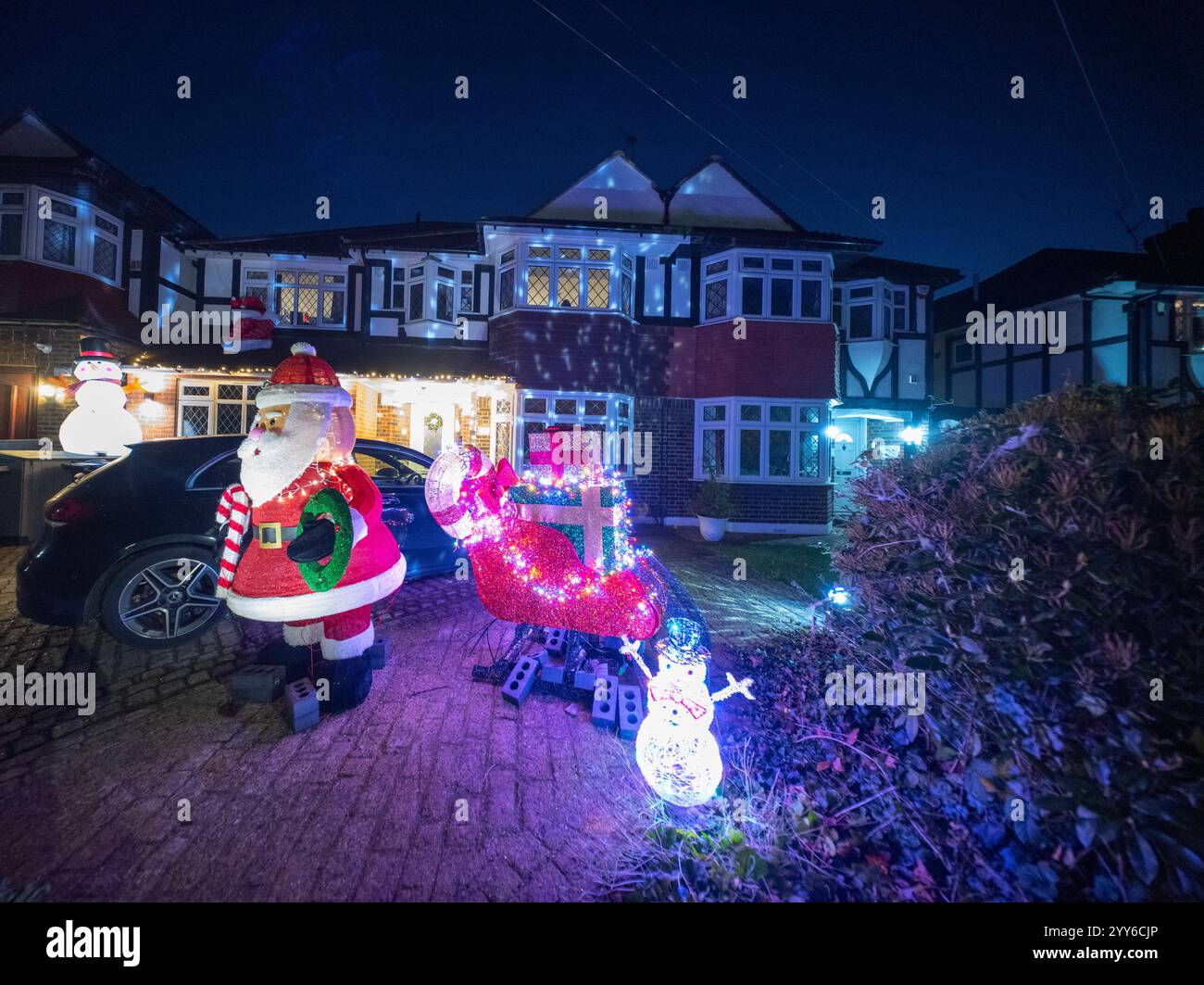 Lower Morden Lane, Surrey, Royaume-Uni. 19 décembre 2024. Les résidents de cette rue résidentielle du sud de Londres décorent l’extérieur de leur maison chaque année, amassant des fonds pour le St Raphael’s Hospice localement qui offre des soins palliatifs et de fin de vie aux habitants de Merton et Sutton. Cette année, ils ont créé une extravagance d'un quart de mile de long de lumières dans les jardins de devant, visités chaque soir par les familles qui apprécient le spectacle. Crédit : Malcolm Park/Alamy Live News Banque D'Images