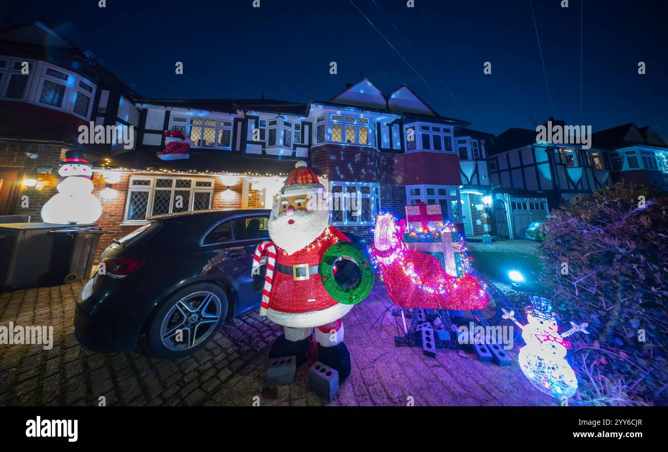 Lower Morden Lane, Surrey, Royaume-Uni. 19 décembre 2024. Les résidents de cette rue résidentielle du sud de Londres décorent l’extérieur de leur maison chaque année, amassant des fonds pour le St Raphael’s Hospice localement qui offre des soins palliatifs et de fin de vie aux habitants de Merton et Sutton. Cette année, ils ont créé une extravagance d'un quart de mile de long de lumières dans les jardins de devant, visités chaque soir par les familles qui apprécient le spectacle. Crédit : Malcolm Park/Alamy Live News Banque D'Images
