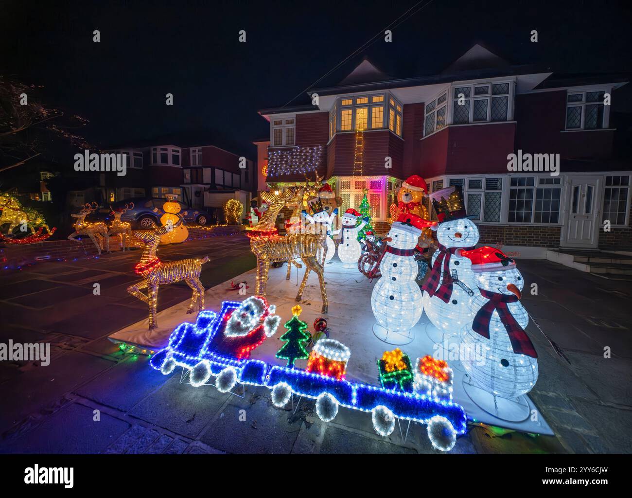 Lower Morden Lane, Surrey, Royaume-Uni. 19 décembre 2024. Les résidents de cette rue résidentielle du sud de Londres décorent l’extérieur de leur maison chaque année, amassant des fonds pour le St Raphael’s Hospice localement qui offre des soins palliatifs et de fin de vie aux habitants de Merton et Sutton. Cette année, ils ont créé une extravagance d'un quart de mile de long de lumières dans les jardins de devant, visités chaque soir par les familles qui apprécient le spectacle. Crédit : Malcolm Park/Alamy Live News Banque D'Images