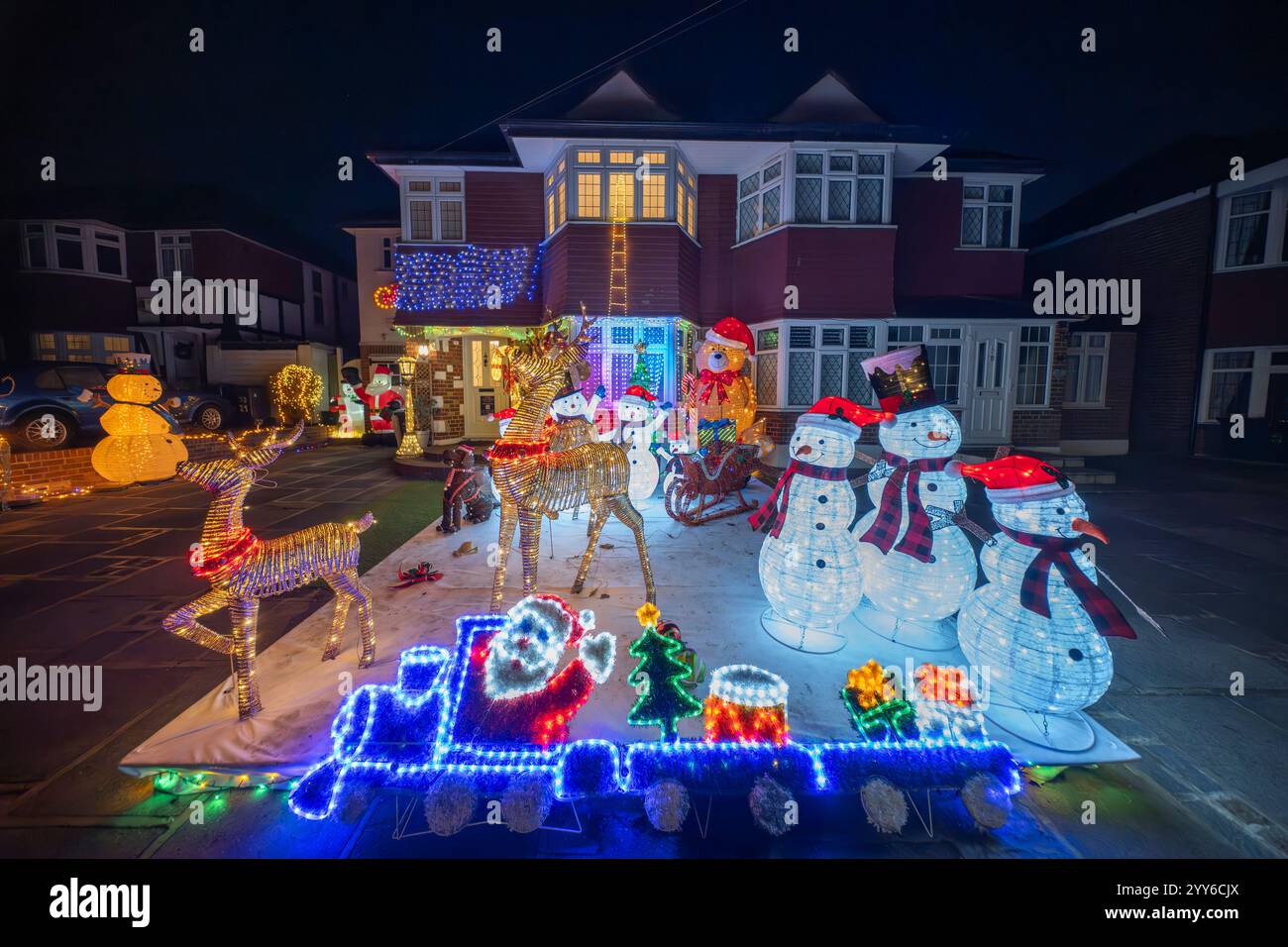 Lower Morden Lane, Surrey, Royaume-Uni. 19 décembre 2024. Les résidents de cette rue résidentielle du sud de Londres décorent l’extérieur de leur maison chaque année, amassant des fonds pour le St Raphael’s Hospice localement qui offre des soins palliatifs et de fin de vie aux habitants de Merton et Sutton. Cette année, ils ont créé une extravagance d'un quart de mile de long de lumières dans les jardins de devant, visités chaque soir par les familles qui apprécient le spectacle. Crédit : Malcolm Park/Alamy Live News Banque D'Images