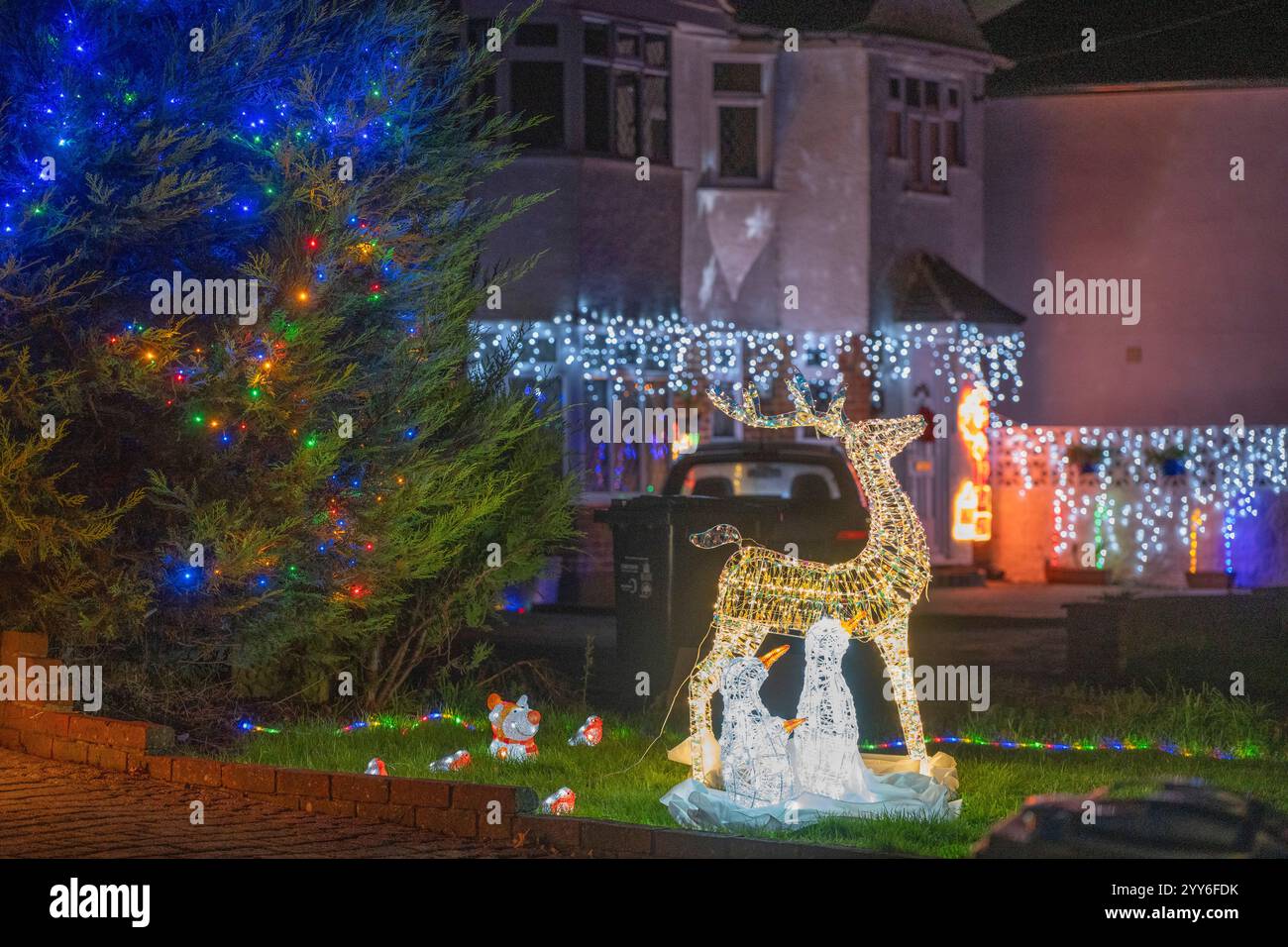 Lower Morden Lane, Surrey, Royaume-Uni. 19 décembre 2024. Les résidents de cette rue résidentielle du sud de Londres décorent l’extérieur de leur maison chaque année, amassant des fonds pour le St Raphael’s Hospice localement qui offre des soins palliatifs et de fin de vie aux habitants de Merton et Sutton. Cette année, ils ont créé une extravagance d'un quart de mile de long de lumières dans les jardins de devant, visités chaque soir par les familles qui apprécient le spectacle. Crédit : Malcolm Park/Alamy Live News Banque D'Images