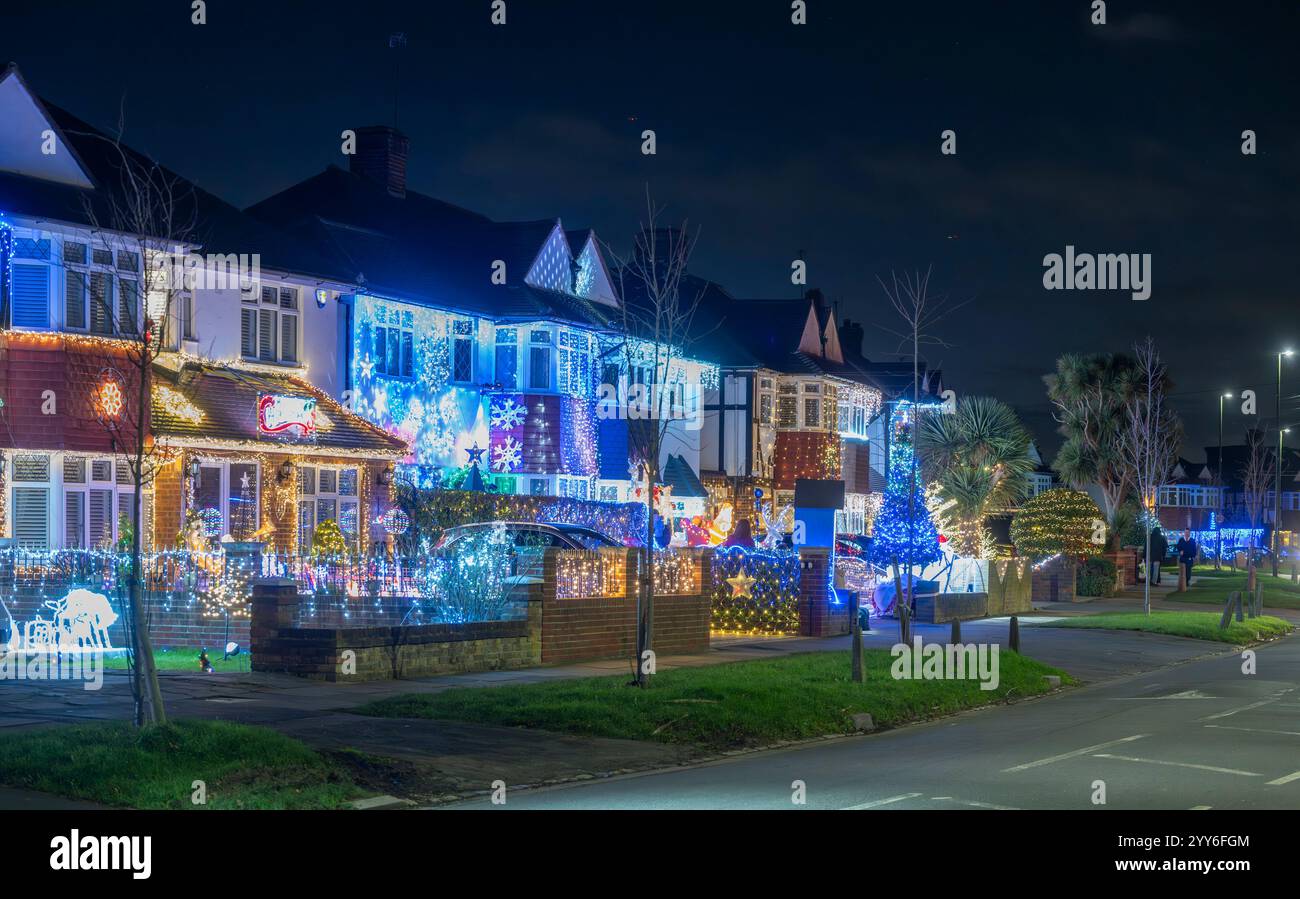 Lower Morden Lane, Surrey, Royaume-Uni. 19 décembre 2024. Les résidents de cette rue résidentielle du sud de Londres décorent l’extérieur de leur maison chaque année, amassant des fonds pour le St Raphael’s Hospice localement qui offre des soins palliatifs et de fin de vie aux habitants de Merton et Sutton. Cette année, ils ont créé une extravagance d'un quart de mile de long de lumières dans les jardins de devant, visités chaque soir par les familles qui apprécient le spectacle. Crédit : Malcolm Park/Alamy Live News Banque D'Images