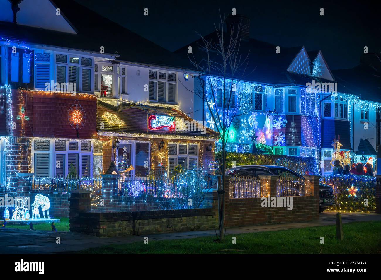 Lower Morden Lane, Surrey, Royaume-Uni. 19 décembre 2024. Les résidents de cette rue résidentielle du sud de Londres décorent l’extérieur de leur maison chaque année, amassant des fonds pour le St Raphael’s Hospice localement qui offre des soins palliatifs et de fin de vie aux habitants de Merton et Sutton. Cette année, ils ont créé une extravagance d'un quart de mile de long de lumières dans les jardins de devant, visités chaque soir par les familles qui apprécient le spectacle. Crédit : Malcolm Park/Alamy Live News Banque D'Images