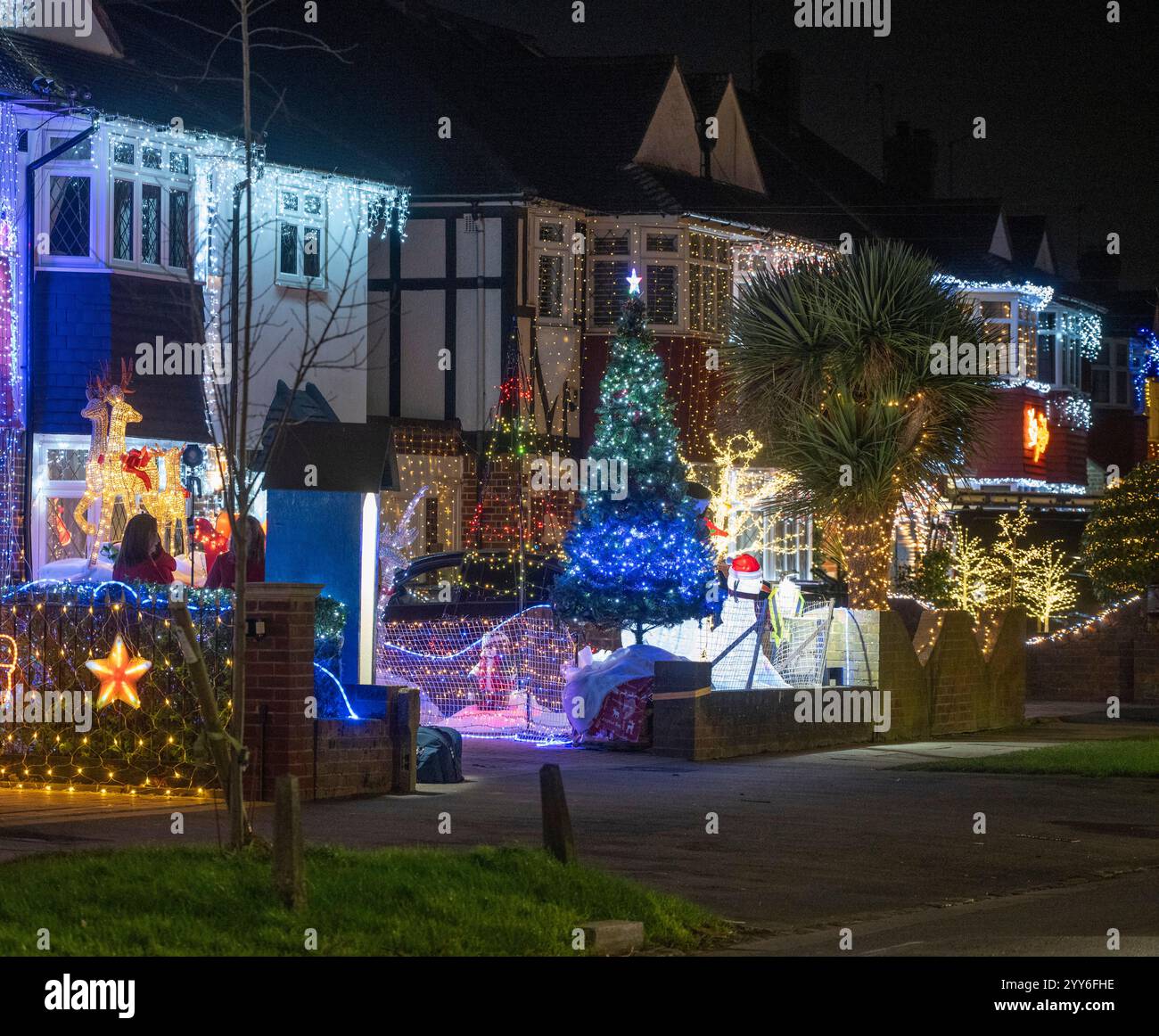 Lower Morden Lane, Surrey, Royaume-Uni. 19 décembre 2024. Les résidents de cette rue résidentielle du sud de Londres décorent l’extérieur de leur maison chaque année, amassant des fonds pour le St Raphael’s Hospice localement qui offre des soins palliatifs et de fin de vie aux habitants de Merton et Sutton. Cette année, ils ont créé une extravagance d'un quart de mile de long de lumières dans les jardins de devant, visités chaque soir par les familles qui apprécient le spectacle. Crédit : Malcolm Park/Alamy Live News Banque D'Images