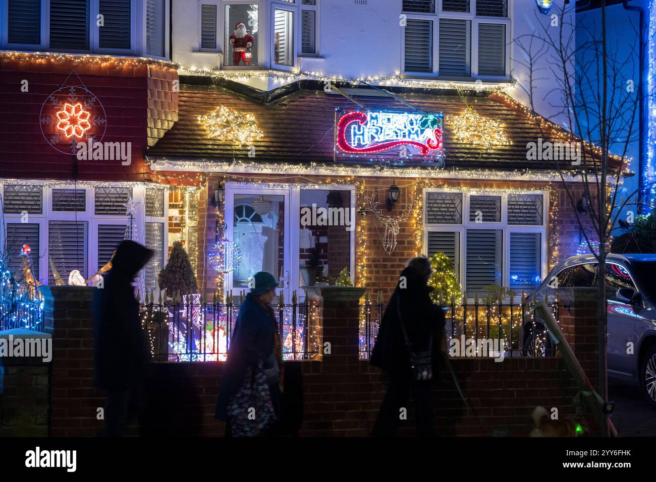 Lower Morden Lane, Surrey, Royaume-Uni. 19 décembre 2024. Les résidents de cette rue résidentielle du sud de Londres décorent l’extérieur de leur maison chaque année, amassant des fonds pour le St Raphael’s Hospice localement qui offre des soins palliatifs et de fin de vie aux habitants de Merton et Sutton. Cette année, ils ont créé une extravagance d'un quart de mile de long de lumières dans les jardins de devant, visités chaque soir par les familles qui apprécient le spectacle. Crédit : Malcolm Park/Alamy Live News Banque D'Images