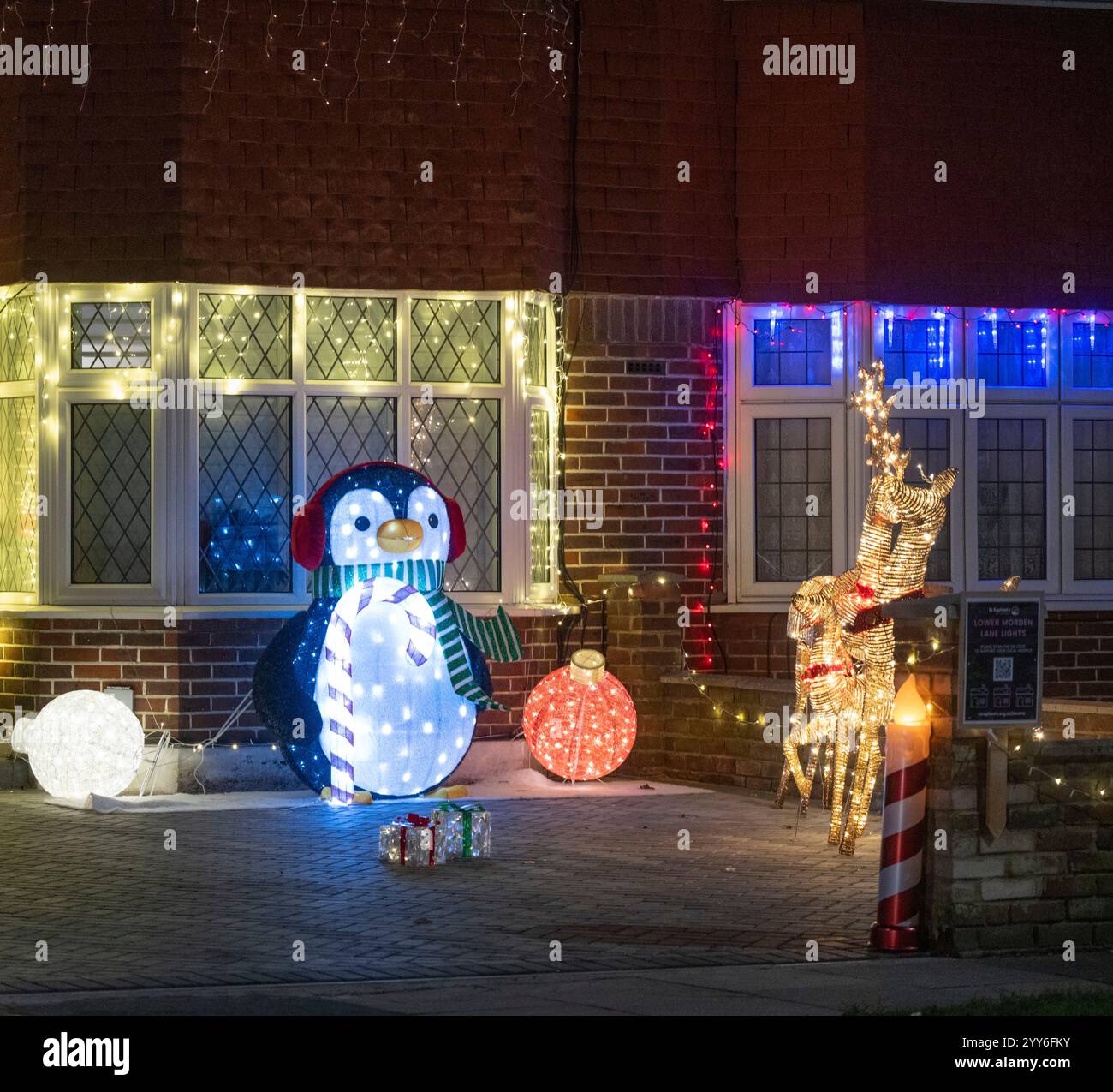 Lower Morden Lane, Surrey, Royaume-Uni. 19 décembre 2024. Les résidents de cette rue résidentielle du sud de Londres décorent l’extérieur de leur maison chaque année, amassant des fonds pour le St Raphael’s Hospice localement qui offre des soins palliatifs et de fin de vie aux habitants de Merton et Sutton. Cette année, ils ont créé une extravagance d'un quart de mile de long de lumières dans les jardins de devant, visités chaque soir par les familles qui apprécient le spectacle. Crédit : Malcolm Park/Alamy Live News Banque D'Images