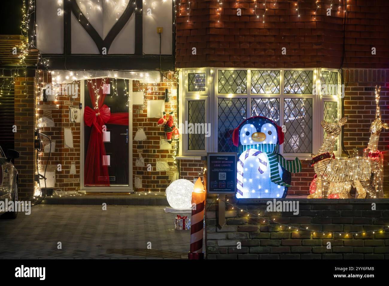 Lower Morden Lane, Surrey, Royaume-Uni. 19 décembre 2024. Les résidents de cette rue résidentielle du sud de Londres décorent l’extérieur de leur maison chaque année, amassant des fonds pour le St Raphael’s Hospice localement qui offre des soins palliatifs et de fin de vie aux habitants de Merton et Sutton. Cette année, ils ont créé une extravagance d'un quart de mile de long de lumières dans les jardins de devant, visités chaque soir par les familles qui apprécient le spectacle. Crédit : Malcolm Park/Alamy Live News Banque D'Images