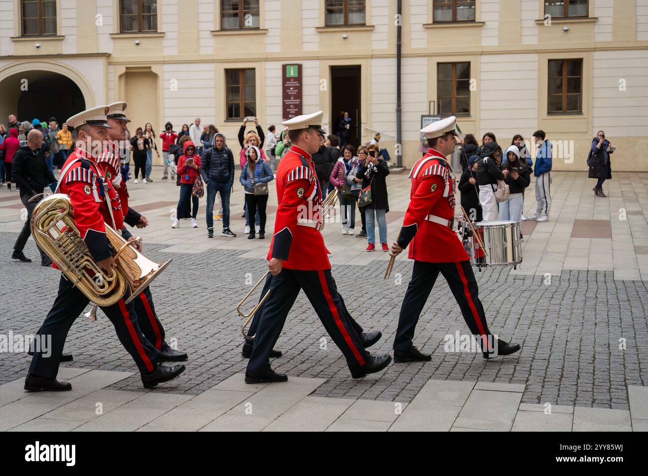 Prague, République tchèque. 4 octobre 2024 - fanfare militaire en uniformes rouges défilant dans le château de Prague Banque D'Images