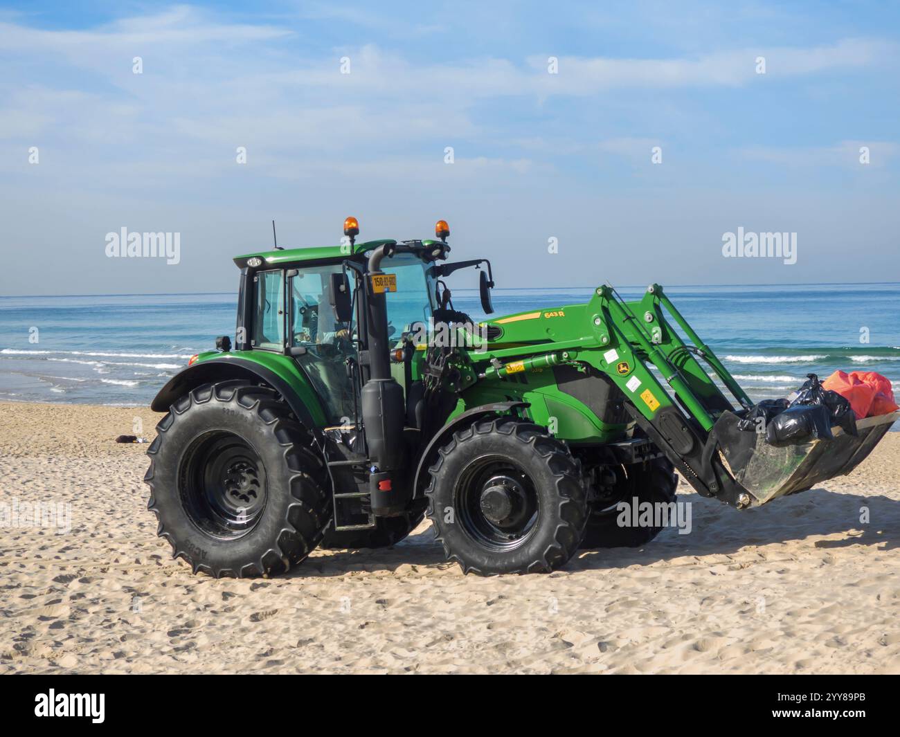 Municipal Tractor nettoie la plage de sable photographiée à Bat Yam, en Israël Banque D'Images