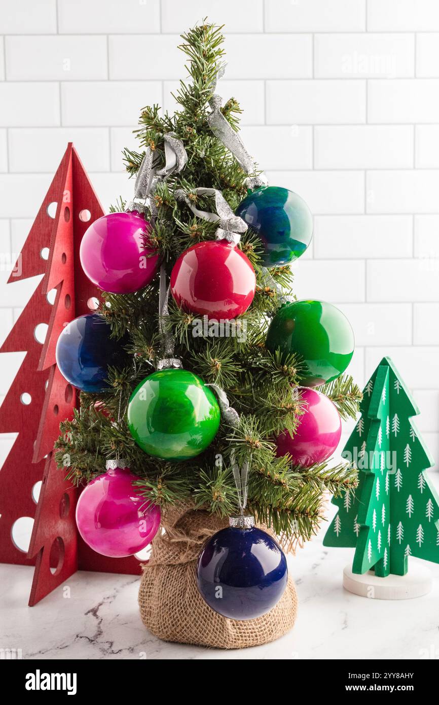 Mini sapin de Noël décoré avec des ornements brillants colorés Banque D'Images