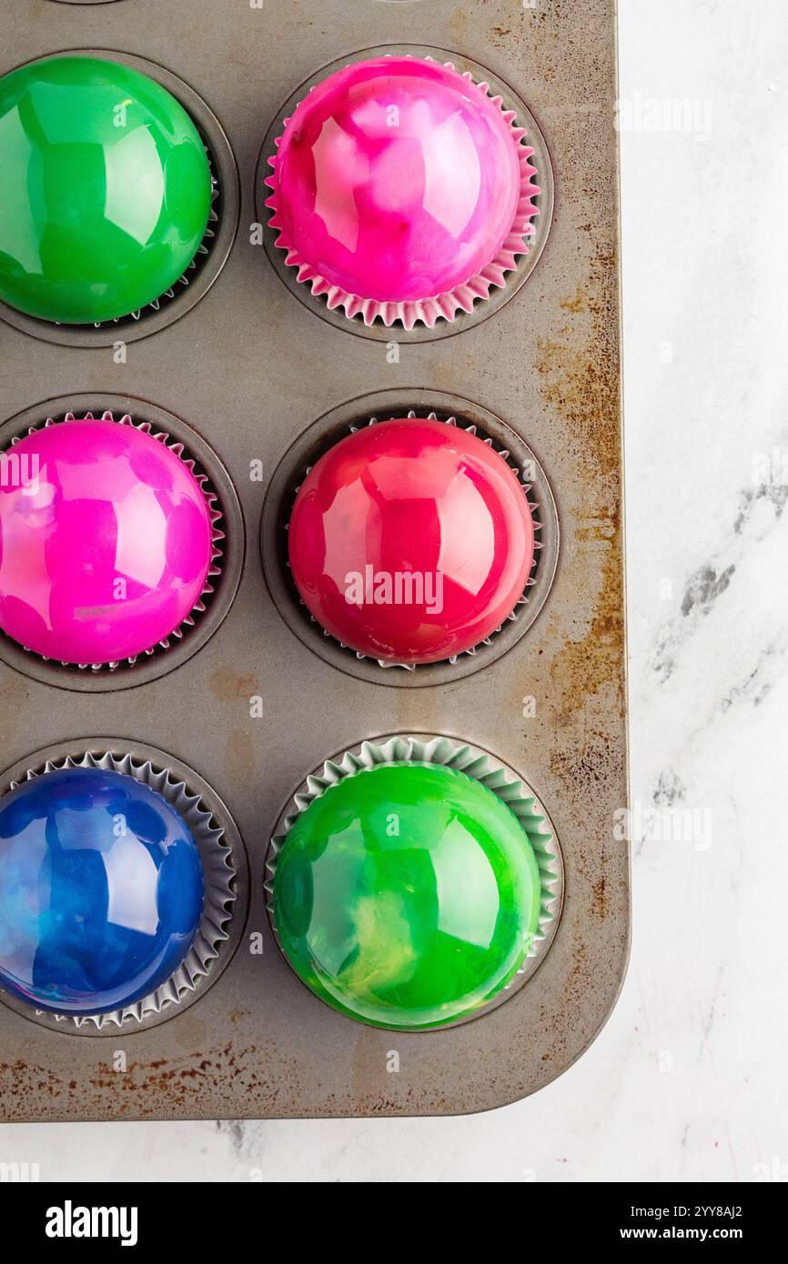 Décorations colorées brillantes placées dans une boîte à muffins avec doublures Banque D'Images