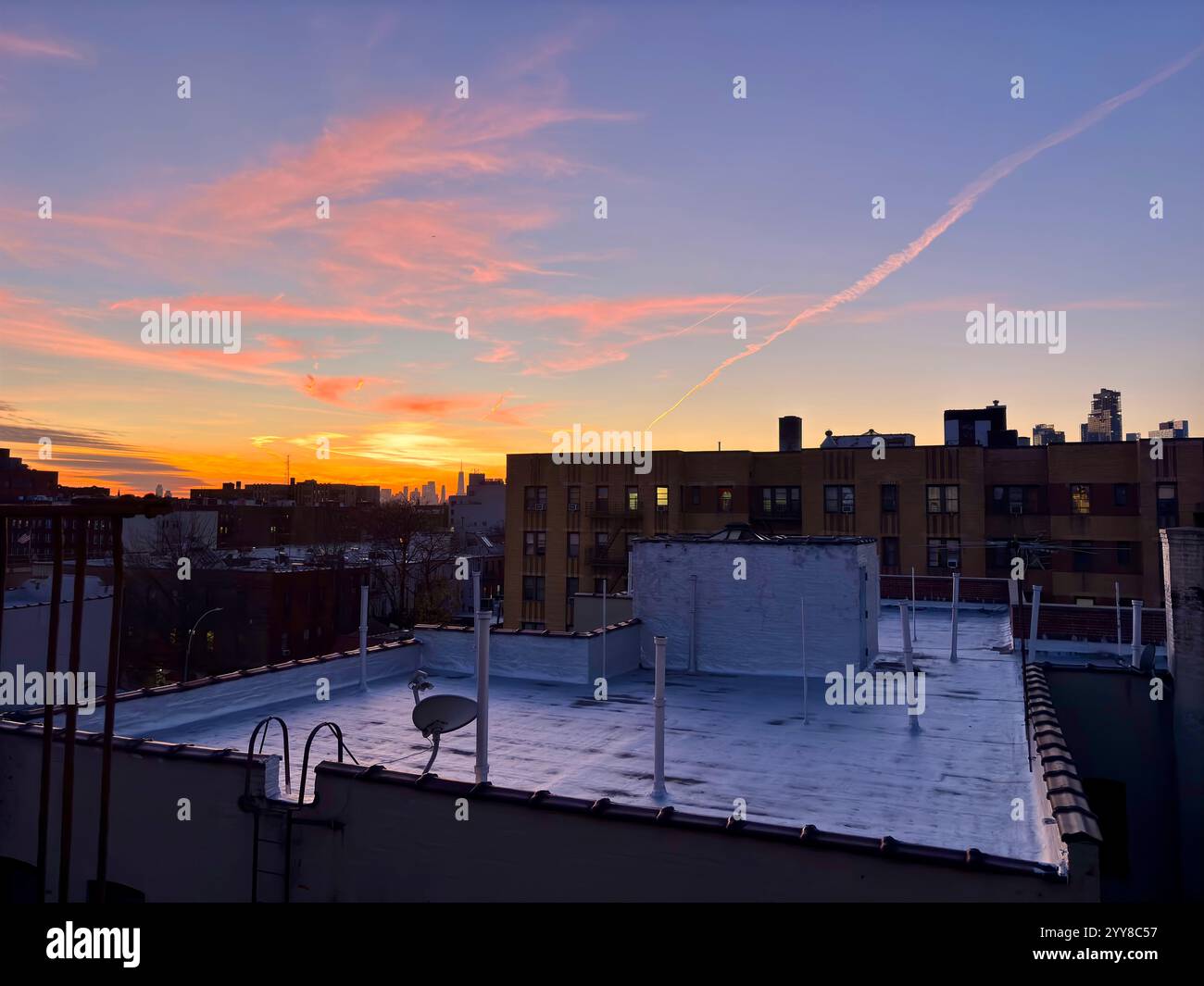 Coucher de soleil sur le toit avec vue lointaine sur la ville de New York Banque D'Images Coucher de soleil sur le toit avec vue lointaine sur la ville de New York Banque D'Images