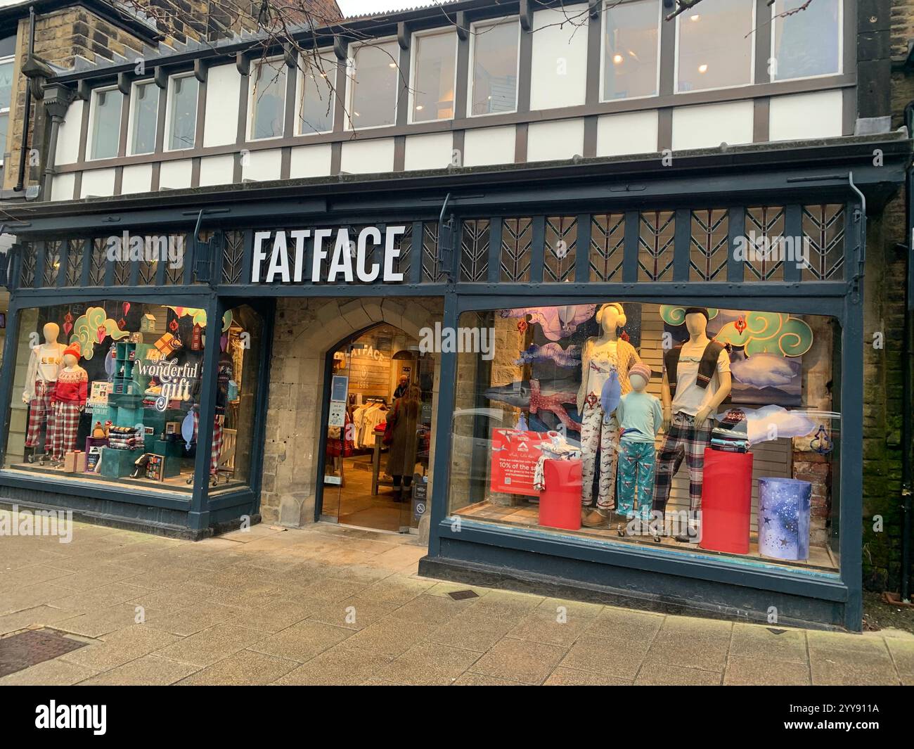 Ilkley Derbyshire magasin magasins de la ville shopping village magasin chemin vue acheter à l'extérieur du centre vêtements de Noël fleurs arc rouge vert avant local place centre - Image de stock capturée avec un smartphone