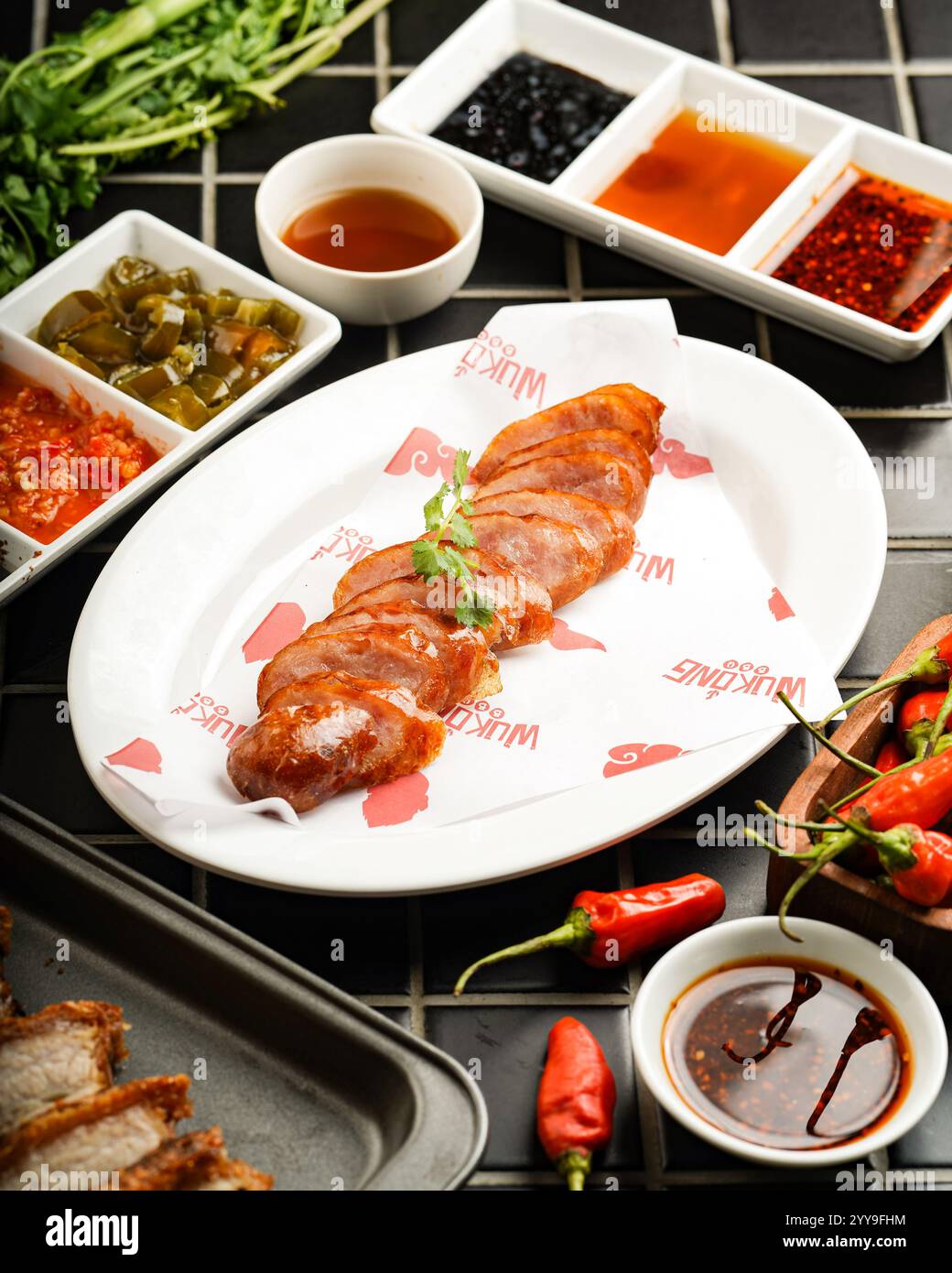 Poitrine de porc croustillante (style lechon kawali), parfaitement tranchée et servie sur un plateau avec une variété de sauces et condiments, accompagnée Banque D'Images