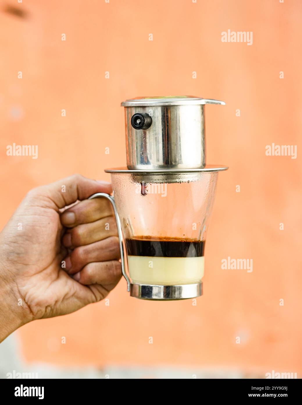 Grand verre de café glacé au lait, rempli de glaçons et servi sur un fond de table blanc Banque D'Images