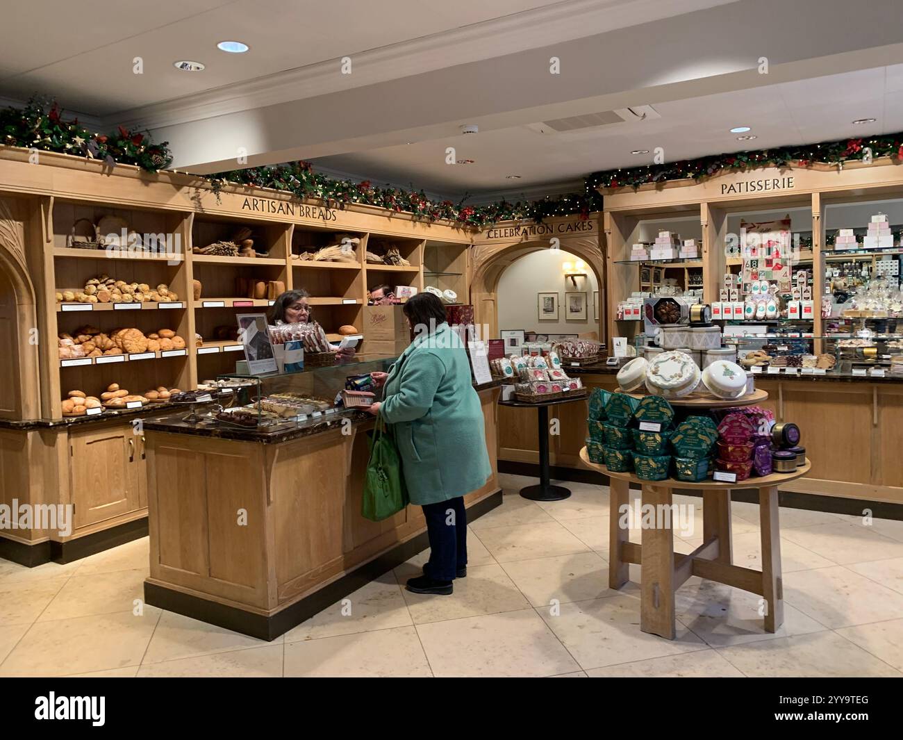 Magasin de thé Betty à Ilkley Yorkshire Angleterre nourriture manger l'après-midi tasse de thé soucoupe crème scones petits pains gâteaux serveuse à l'intérieur du stand magasin personne - Image de stock capturée avec un smartphone