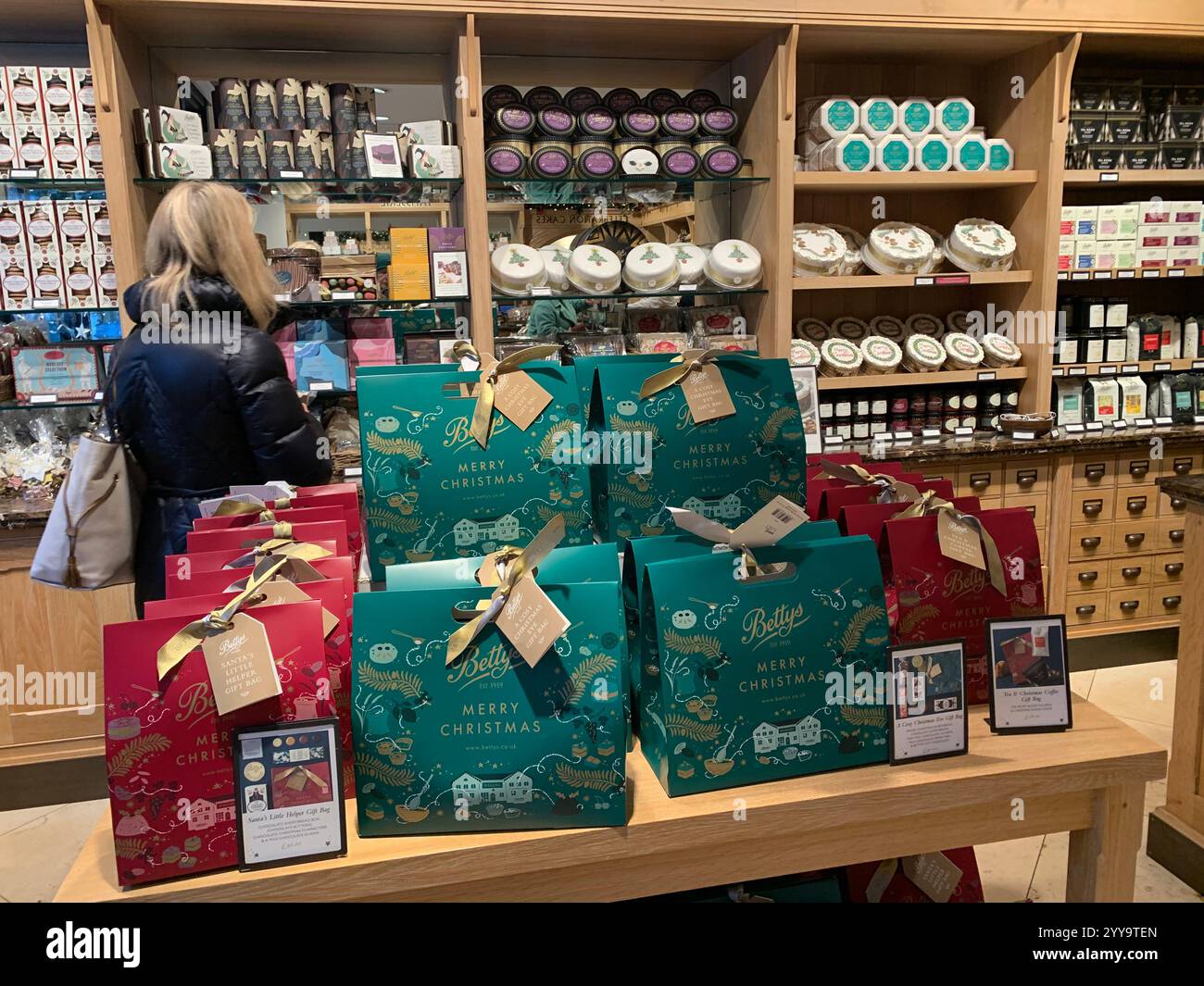 Magasin de thé Betty à Ilkley Yorkshire Angleterre nourriture manger l'après-midi tasse de thé soucoupe crème scones petits pains gâteaux serveuse à l'intérieur du stand magasin personne - Image de stock capturée avec un smartphone