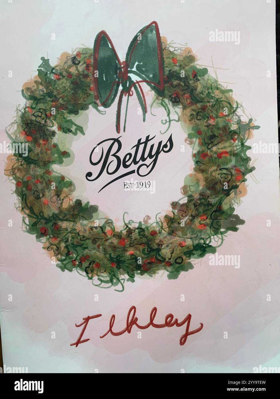 Magasin de thé Betty à Ilkley Yorkshire Angleterre nourriture manger l'après-midi tasse de thé soucoupe crème scones petits pains gâteaux serveuse à l'intérieur du stand magasin personne - Image de stock capturée avec un smartphone
