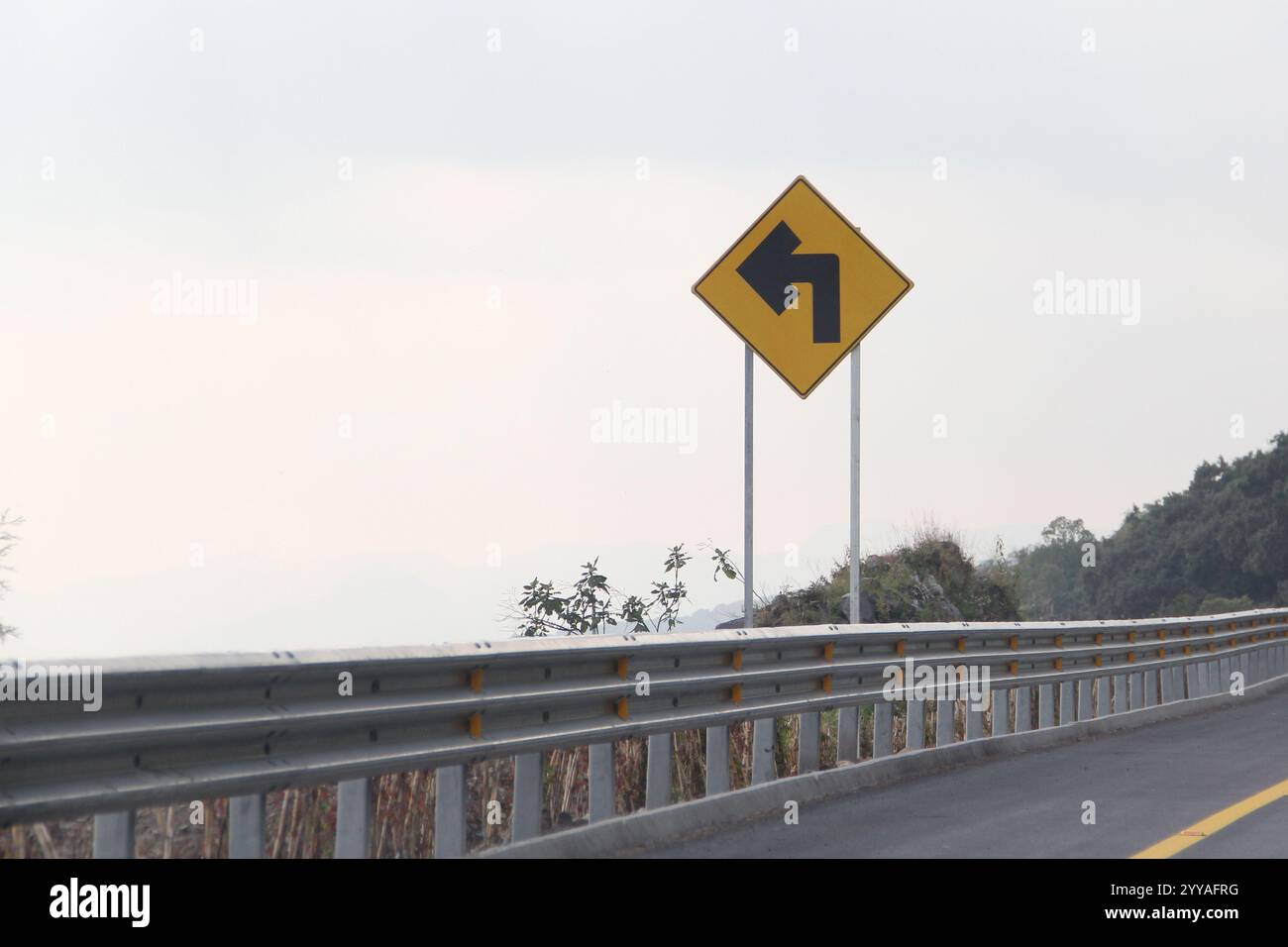 La flèche à gauche d'un virage sur la route indique le mouvement autorisé aux conducteurs circulant dans cette voie Banque D'Images