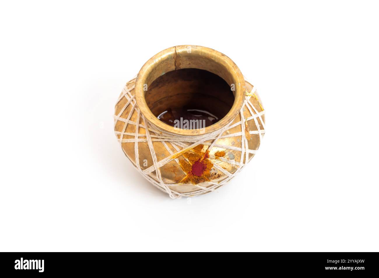 Gros plan d'un pot en laiton traditionnel avec décoration en fil blanc et marque rouge symbolique, couramment utilisé dans les contextes cérémoniels ou religieux. Culte Banque D'Images Gros plan d'un pot en laiton traditionnel avec décoration en fil blanc et marque rouge symbolique, couramment utilisé dans les contextes cérémoniels ou religieux. Culte Banque D'Images