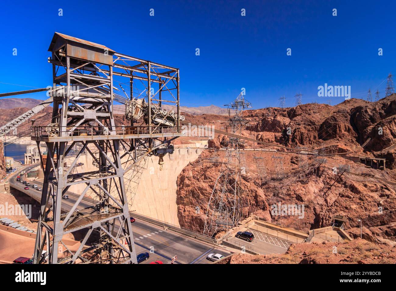 Une grande structure est vue au loin, avec un ciel bleu au-dessus. La scène est d'un paysage désertique, avec une route et une ligne électrique qui le traverse Banque D'Images