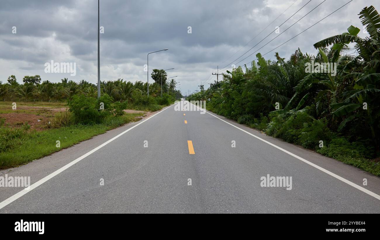 Un long tronçon de route publique droite avec des marquages routiers en Thaïlande Asie. Banque D'Images