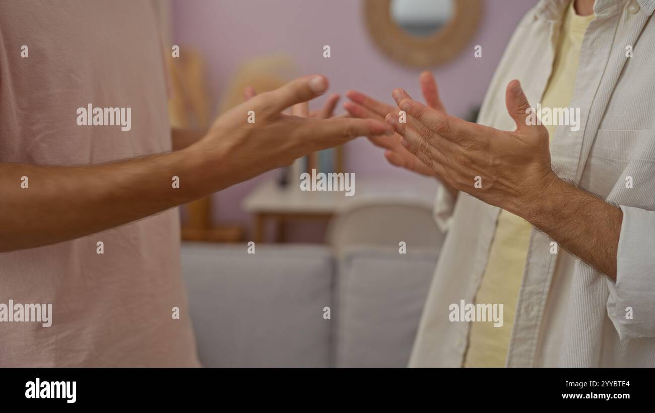 Hommes ayant une discussion animée à la maison avec des gestes de la main dans un salon confortable Banque D'Images