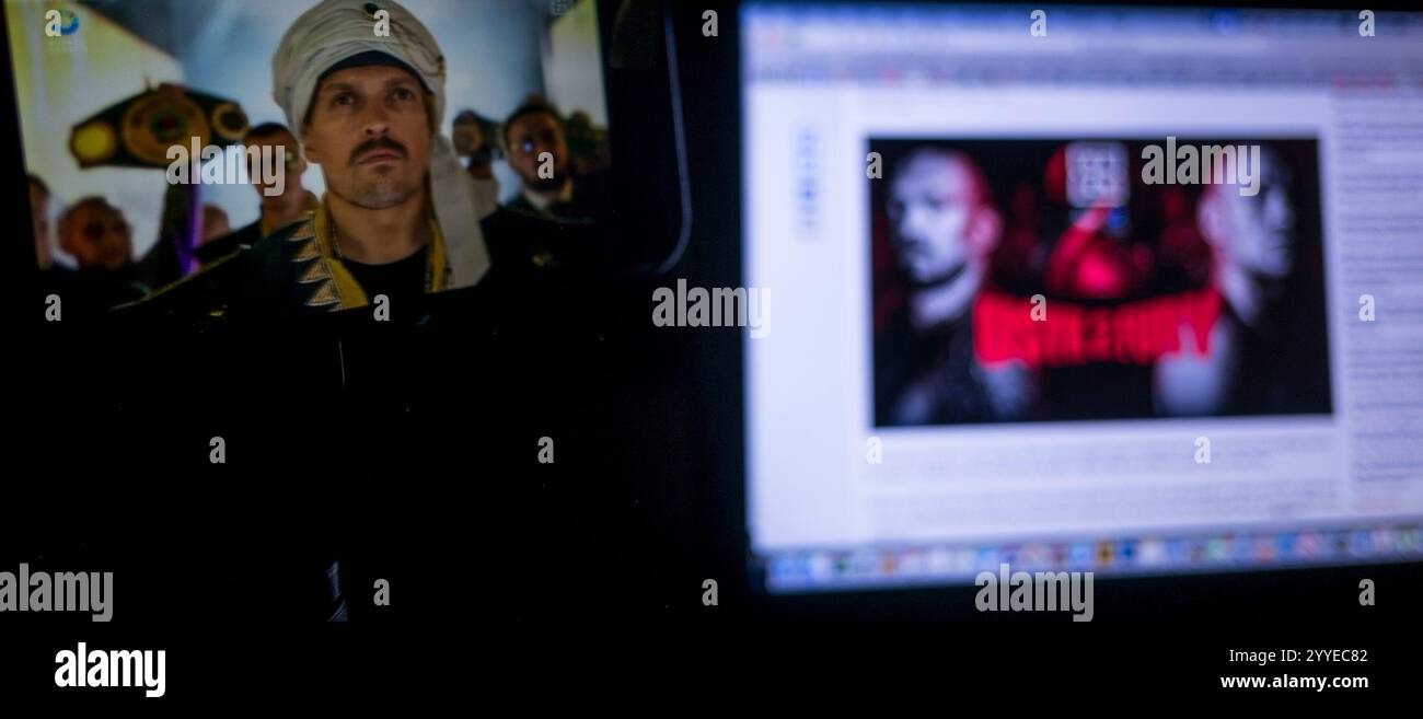 21 décembre 2024, New York City, New York, États-Unis : Heavyweight championnat boxe match entre Alexander Usyk et Tyson Fury diffusé sur un iPhone d'Apple sur l'application DAZN avec une image.in promotionnelle stagnante le fond sur un Apple MacBook Pro. Alexander Usyk entre sur le ring. (Crédit image : © Billy Tompkins/ZUMA Press Wire) USAGE ÉDITORIAL SEULEMENT! Non destiné à UN USAGE commercial ! Banque D'Images